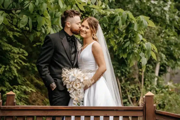 Groom kiss bride on cheek