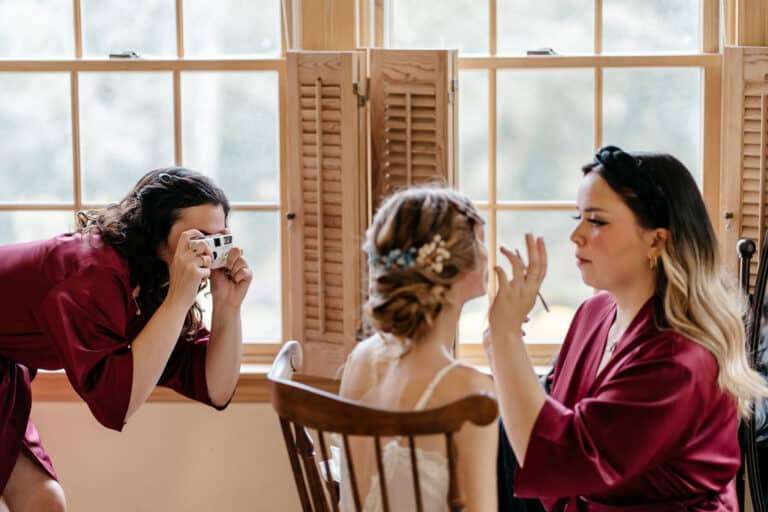 Bridesmaid taking a photo of the bride | Love in Focus Studio