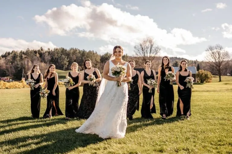 Bride and bridesmaids at a vineyard wedding in New England with rustic countryside backdrop