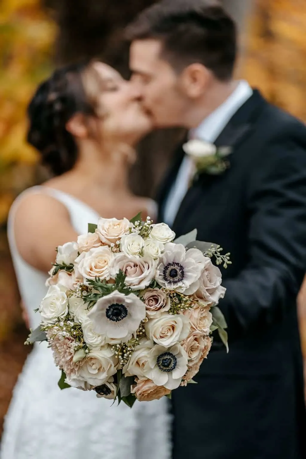 Wedding bouquet with the bride and the groom on the background | Love in Focus Studio