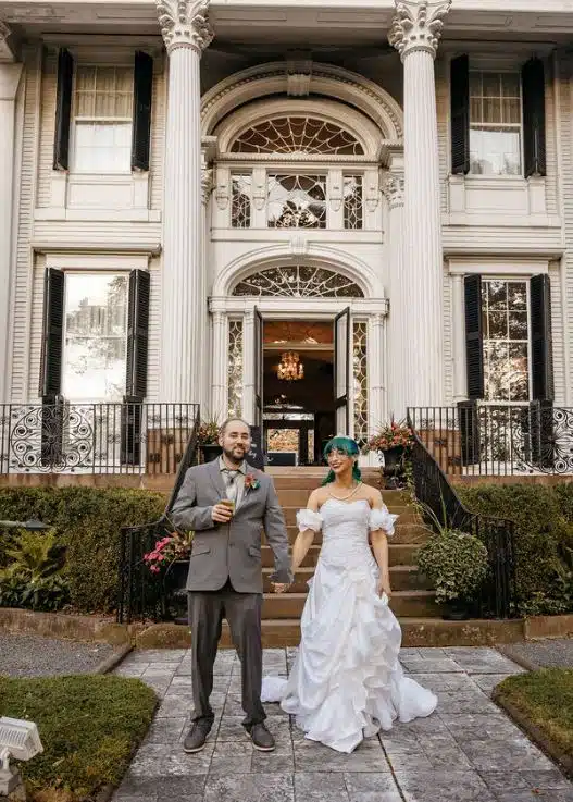 A bride and groom stand before the grand entrance of Linden Place Mansion in Bristol, Rhode Island.