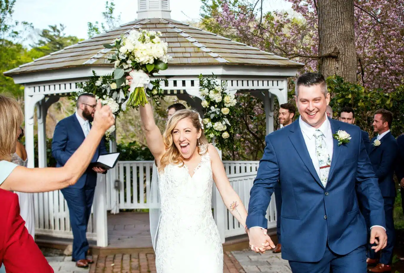 A joyful bride cheers as she and the groom walk down the aisle after their ceremony at The Coonamesset in Falmouth, MA.