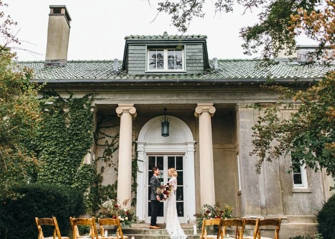 A bride and groom stand outside the Eolia Mansion at Harkness State Park in Waterford, Connecticut.