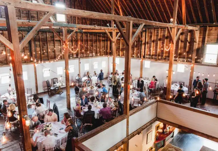 An overhead view of a wedding reception inside the rustic barn at Gedney Farm in New Marlborough, Massachusetts.