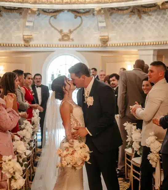 A bride and groom share their first kiss as they walk down the aisle at the Lenox Hotel in Boston, Massachusetts.