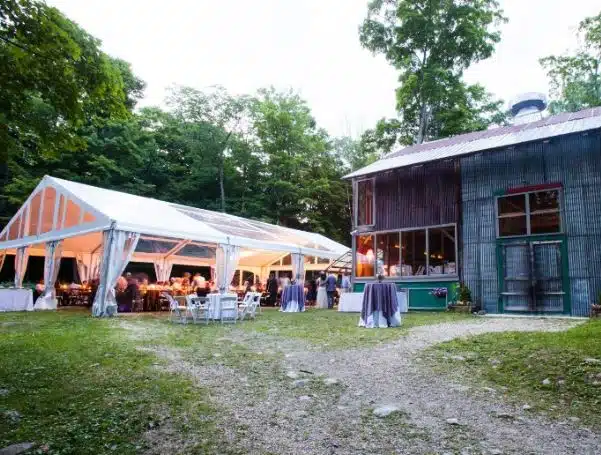 A wedding reception in a tent next to the rustic barn at Race Brook Lodge in Sheffield, Massachusetts.