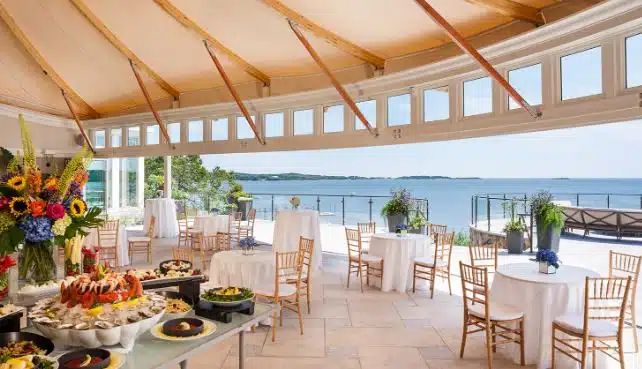 A wedding reception at Wequassett Resort in Harwich, MA, with a seafood buffet and tables overlooking the ocean.