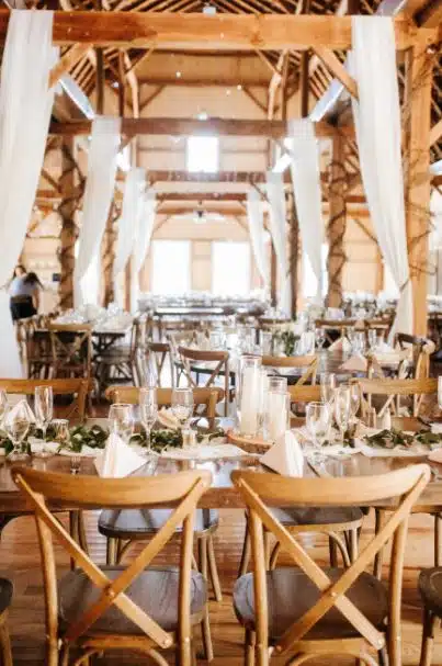 A rustic barn wedding reception at The Ranch Golf Club in Southwick, Massachusetts, with tables set for guests.