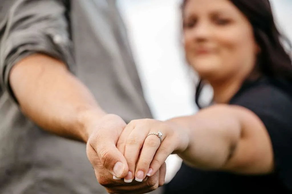 Close-up of a couple's hands showing off a new engagement ring