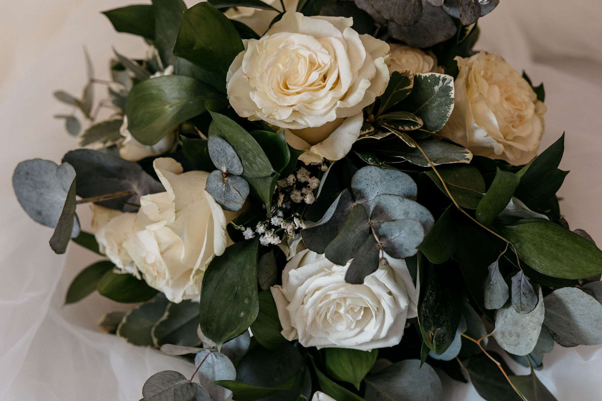 Close-up of a white rose and eucalyptus bridal bouquet