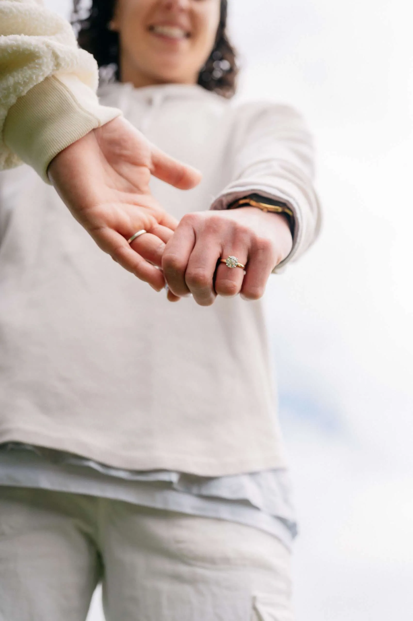 Ashley holding Alanah's hand while showing her engagement ring during their lesbian wedding photography session with Love In Focus.
