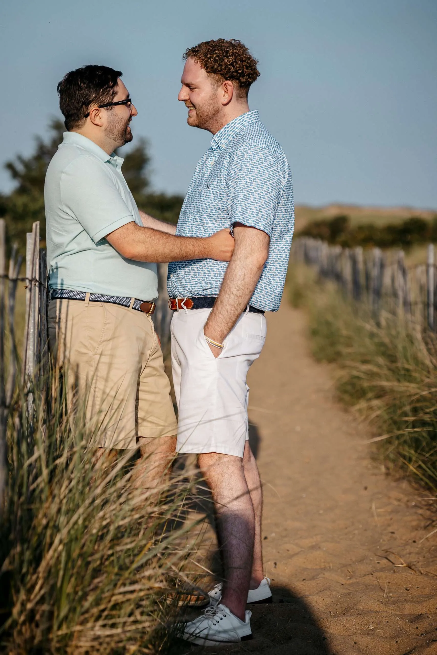 Bobby and James posing for their gay engagement photos on the beach at Plum Island, New York.