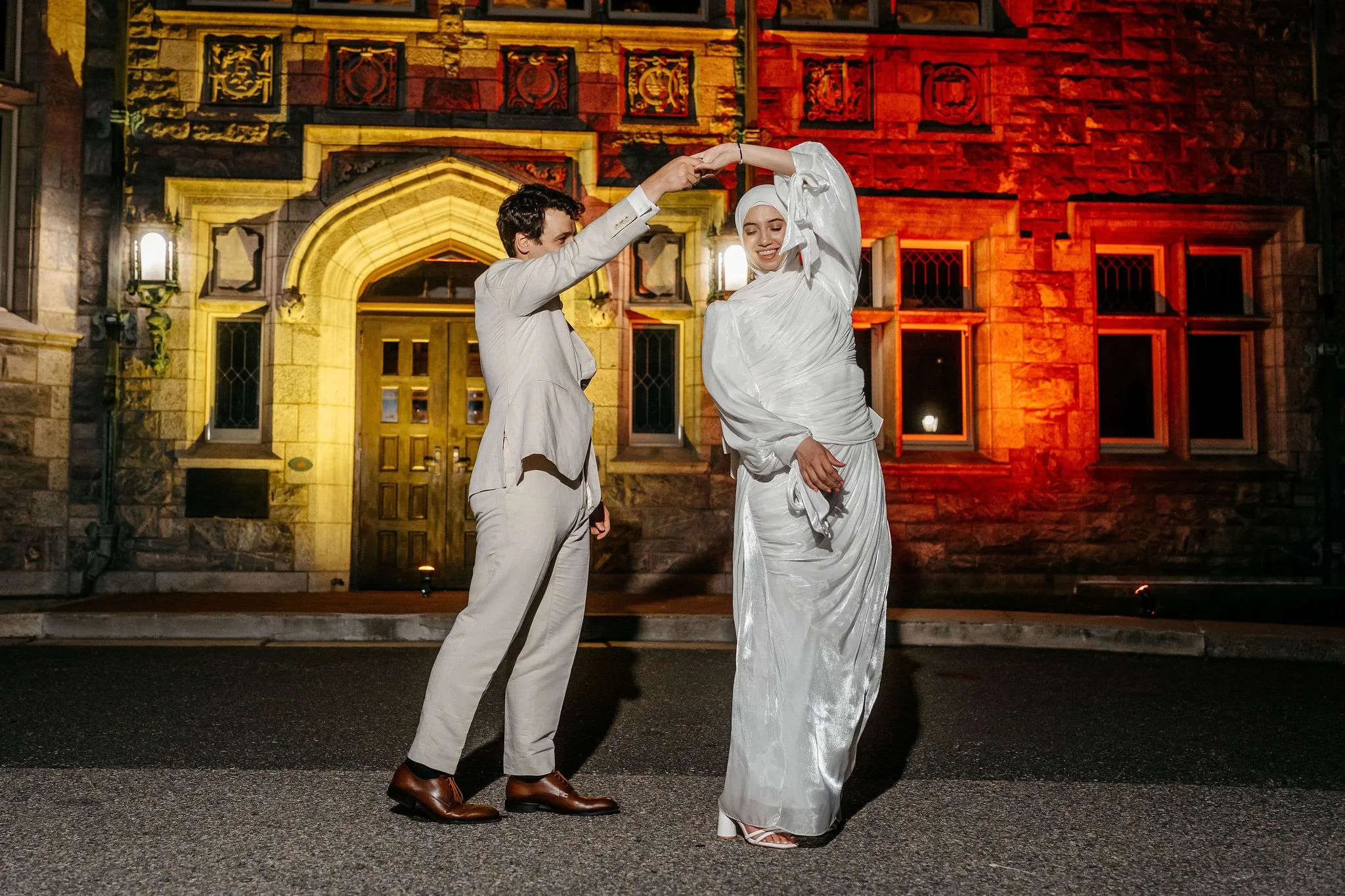 Couple dancing at night in front of the illuminated Gothic entrance of The Branford House in Groton, Connecticut.