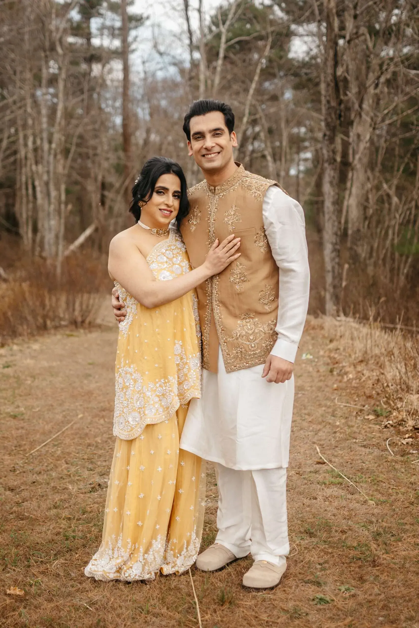 A bride and groom in traditional Indian wedding attire pose for a photo before their State Room wedding in Boston, MA.