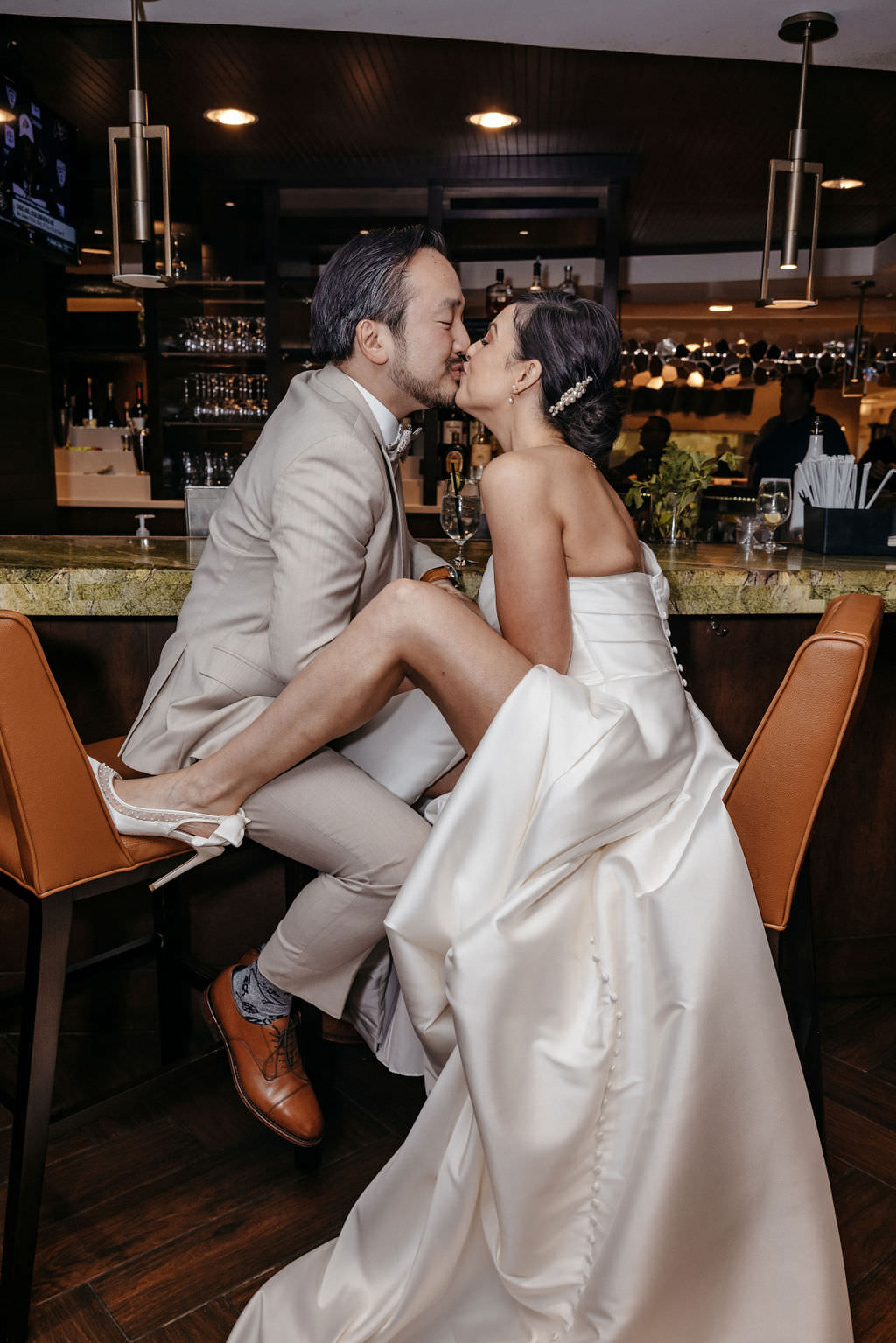 Bride and groom kissing at the hotel bar at the Boston Marriott Burlington