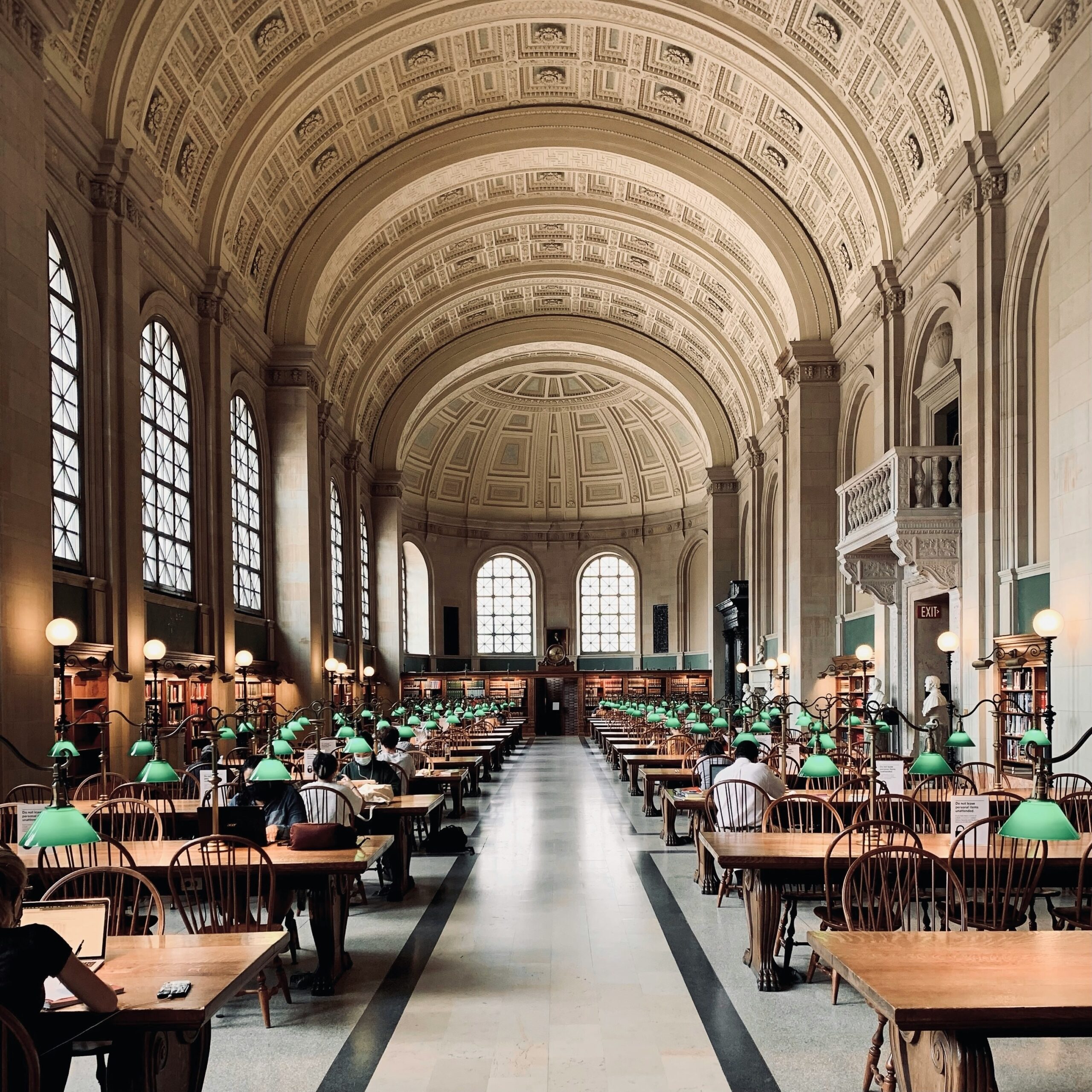 Vaulted reading room of the Boston Public Library with its iconic green lamps