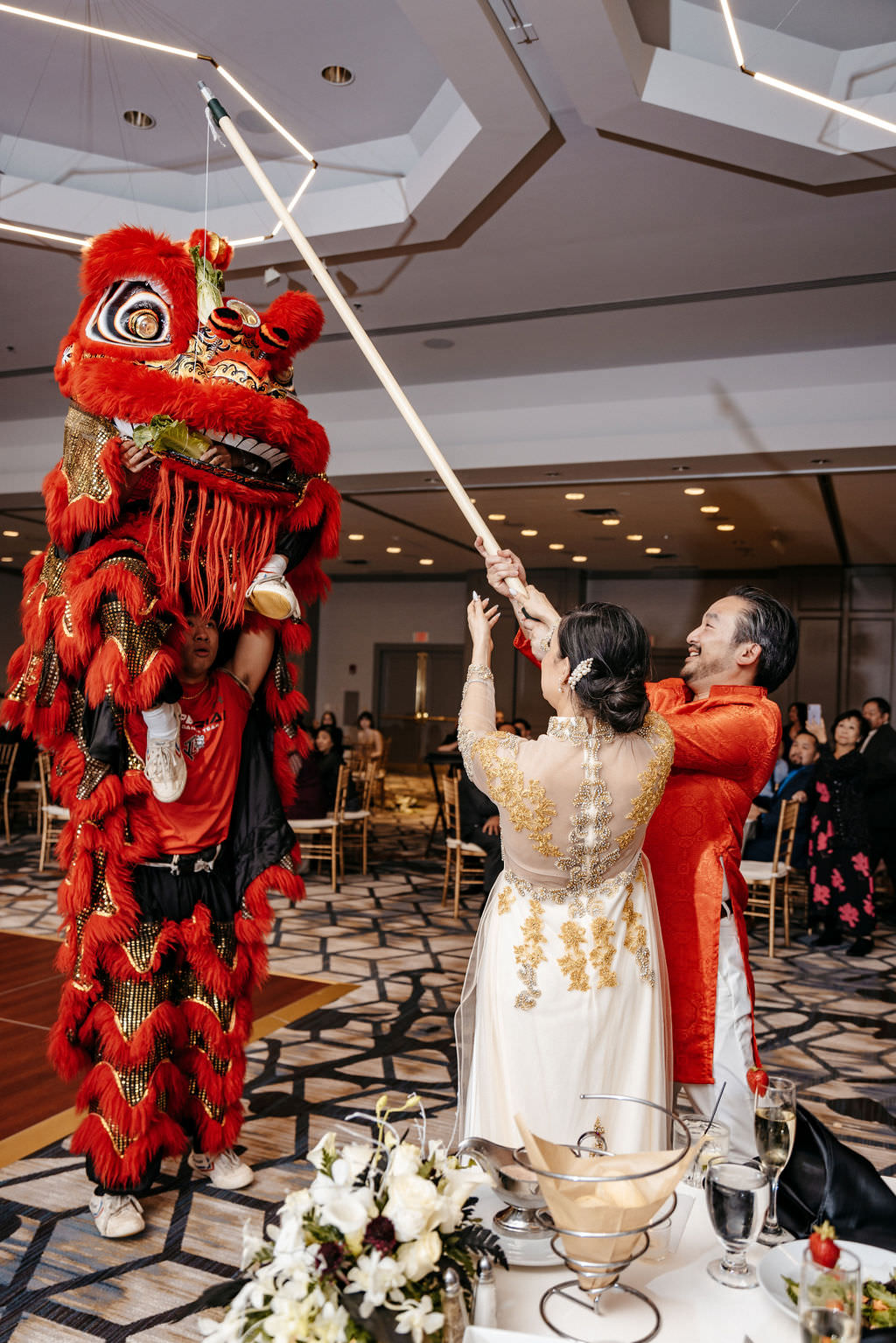 Newlyweds taking part in a lion dance at their Marriott Burlington reception