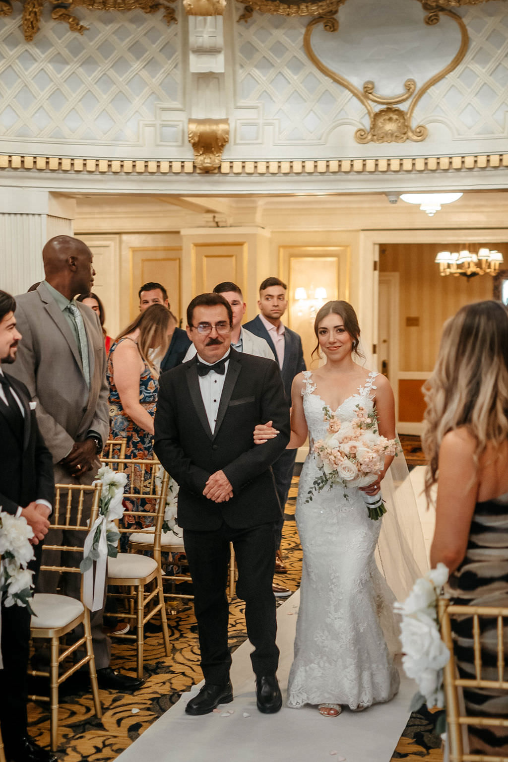 Father escorting the bride down the aisle in an ornate gold-and-white ballroom