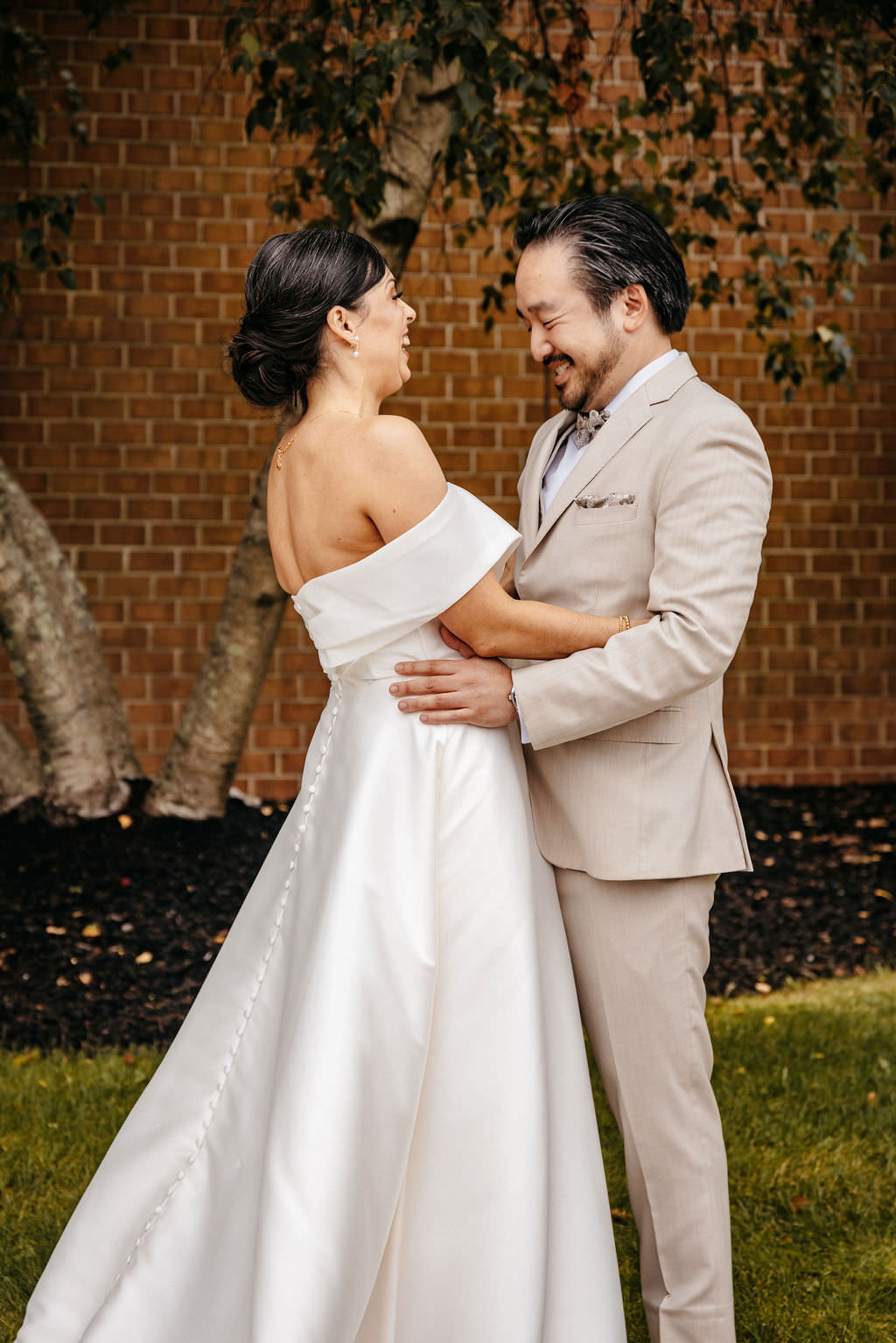 Bride and groom laughing face to face outside the Boston Marriott Burlington