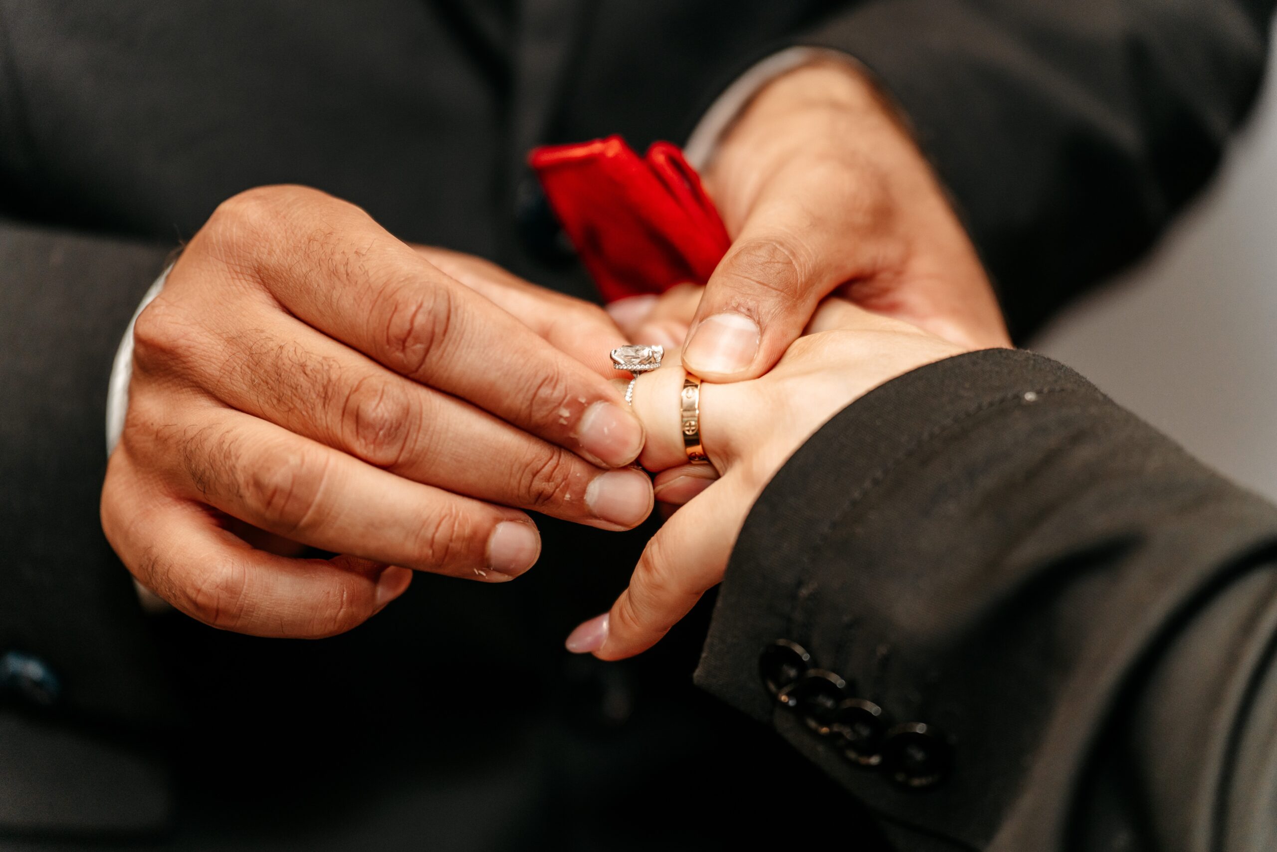Close-up of a ring being placed on a partner's finger at a city hall ceremony