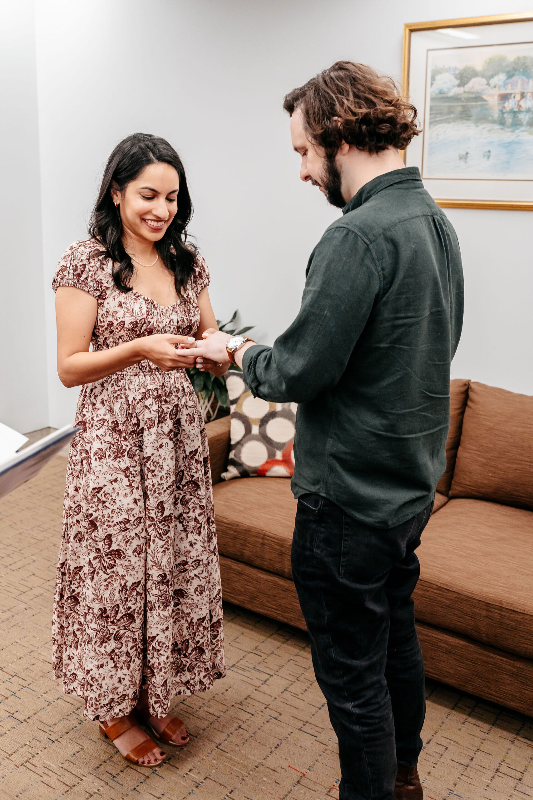 Groom placing the ring on his smiling bride at their Boston City Hall wedding