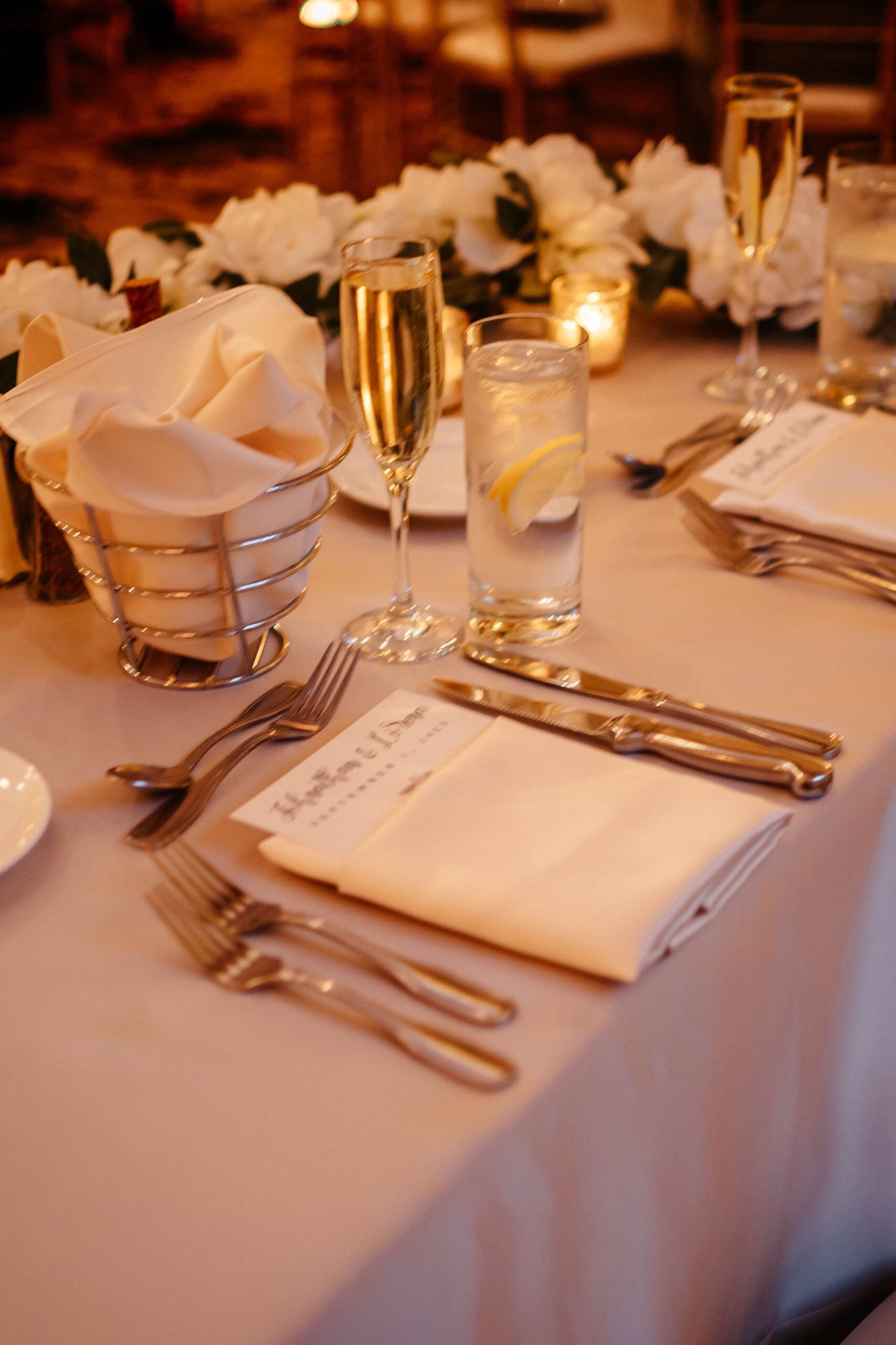 Elegant wedding reception table setting at Boston hotel wedding venue with champagne, candles, and floral centerpiece