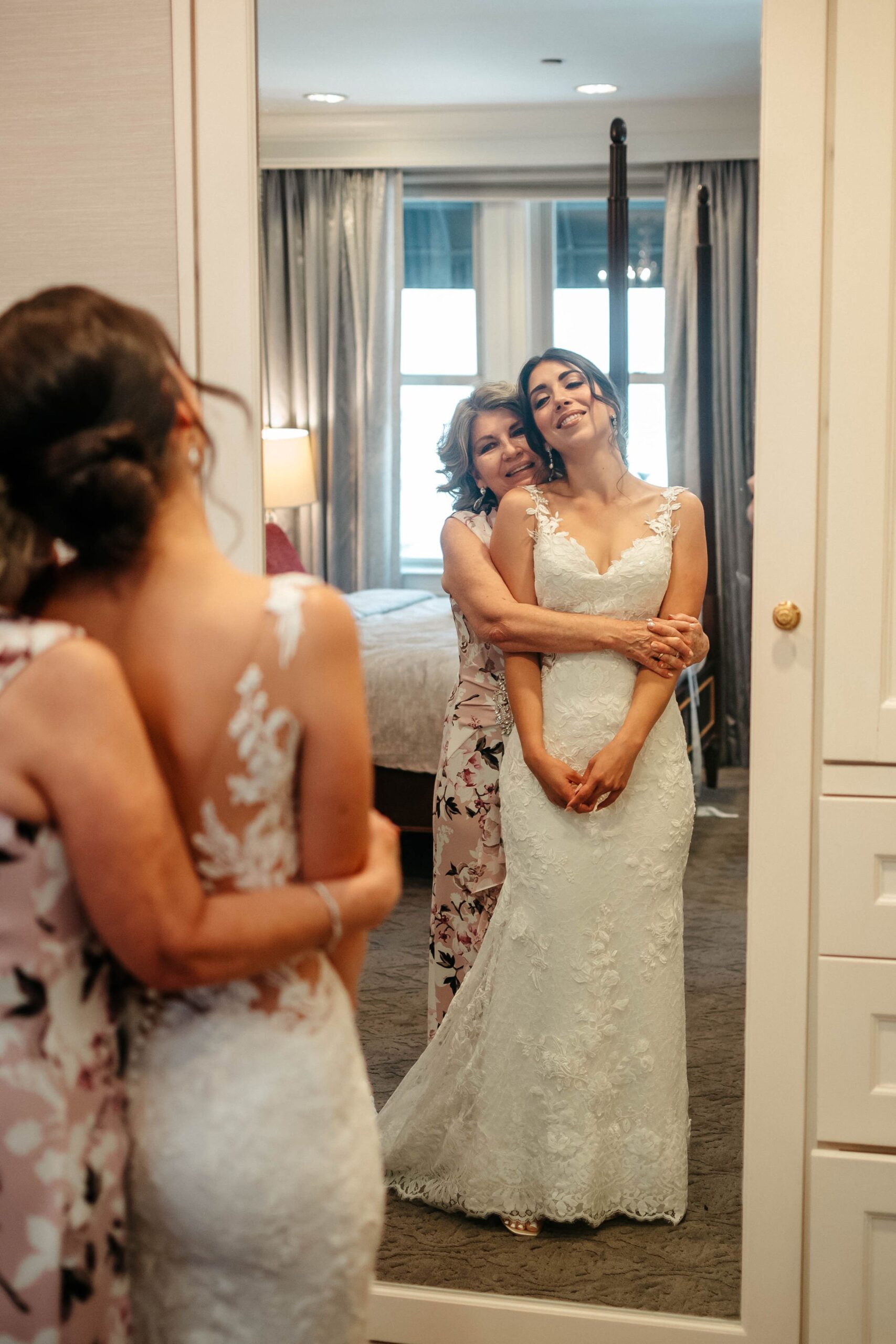 Bride and mother sharing emotional moment in mirror at Boston hotel wedding venue getting ready suite
