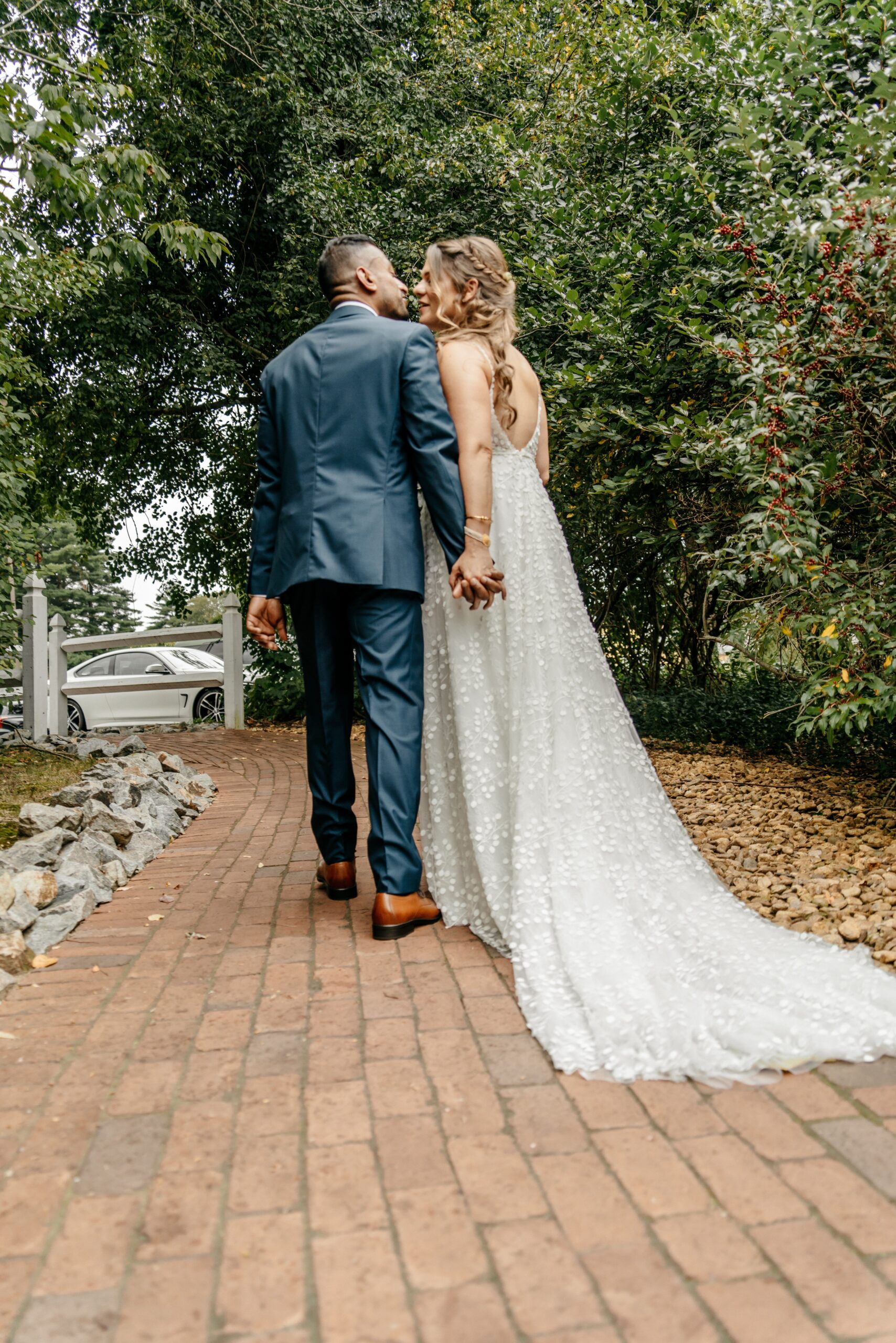 Bride and groom walking hand in hand on garden path during Boston wedding planning day
