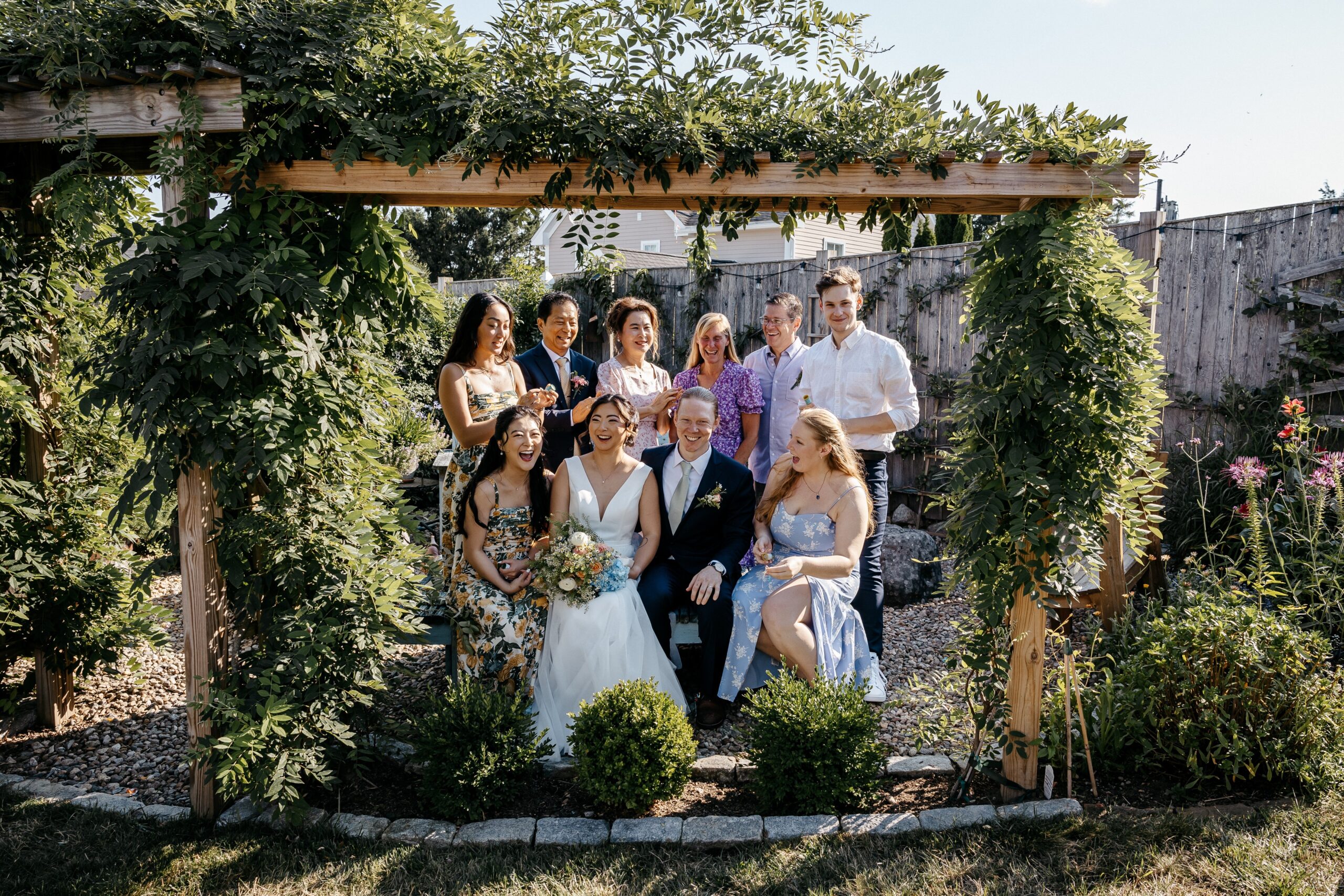 Wedding party celebrating together in garden during Boston wedding planning day