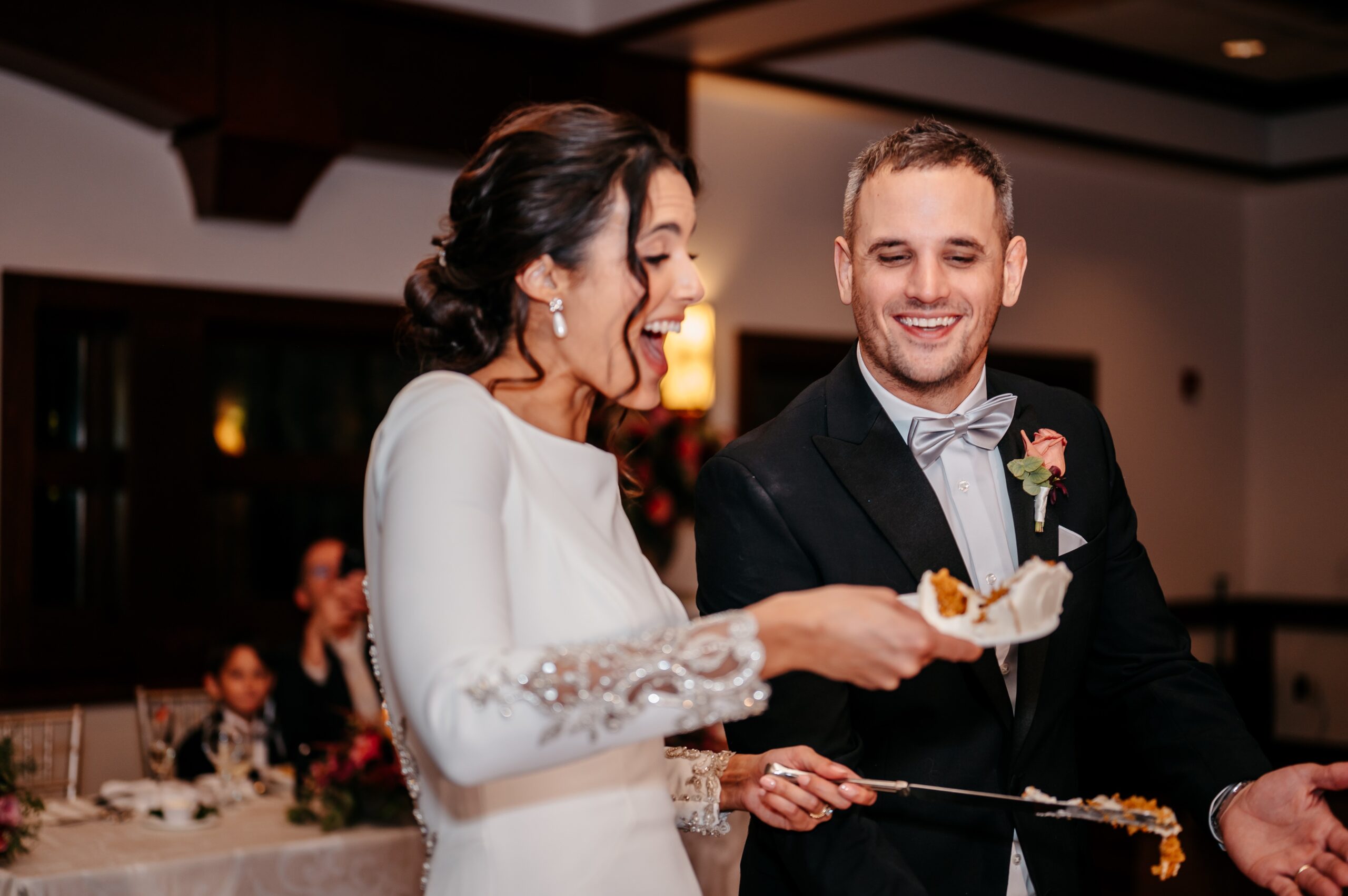 Bride and groom cutting cake during elegant Boston wedding planning reception