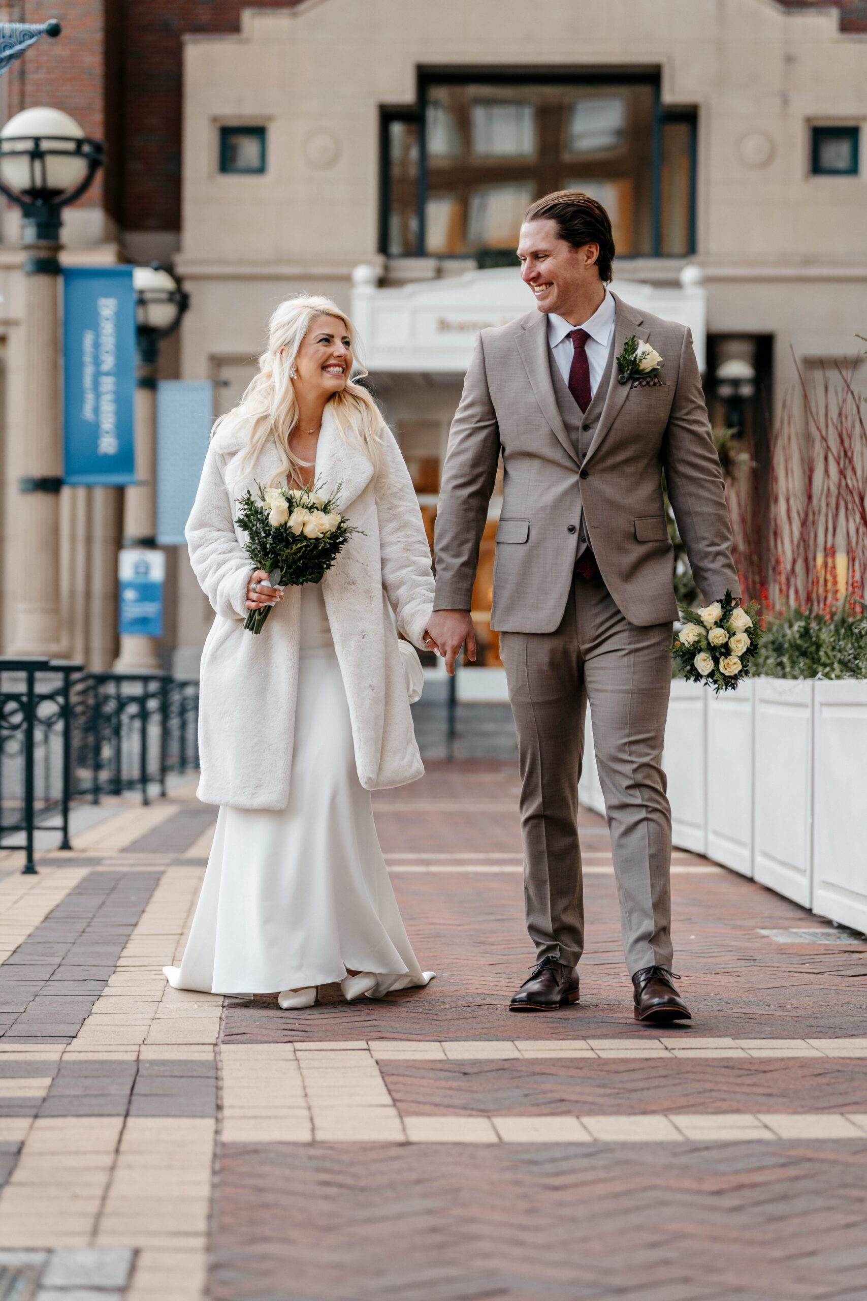 Bride and groom walking together outdoors during Boston wedding planning session