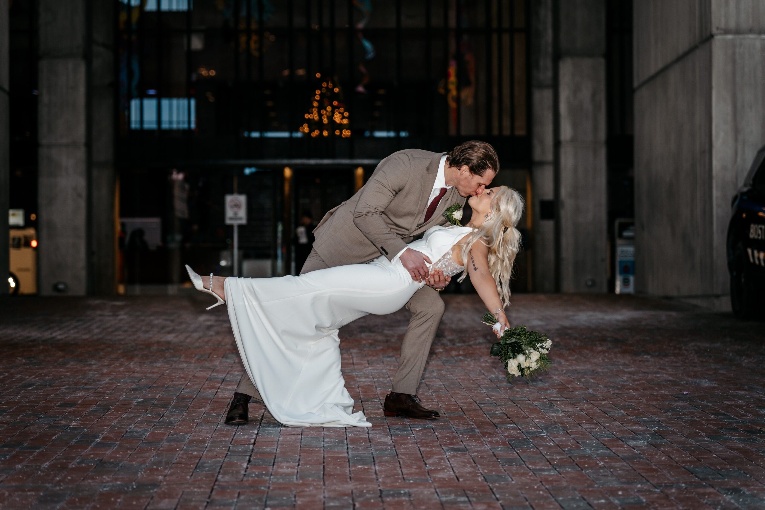 Bride and groom romantic dip kiss at night during Boston wedding celebration