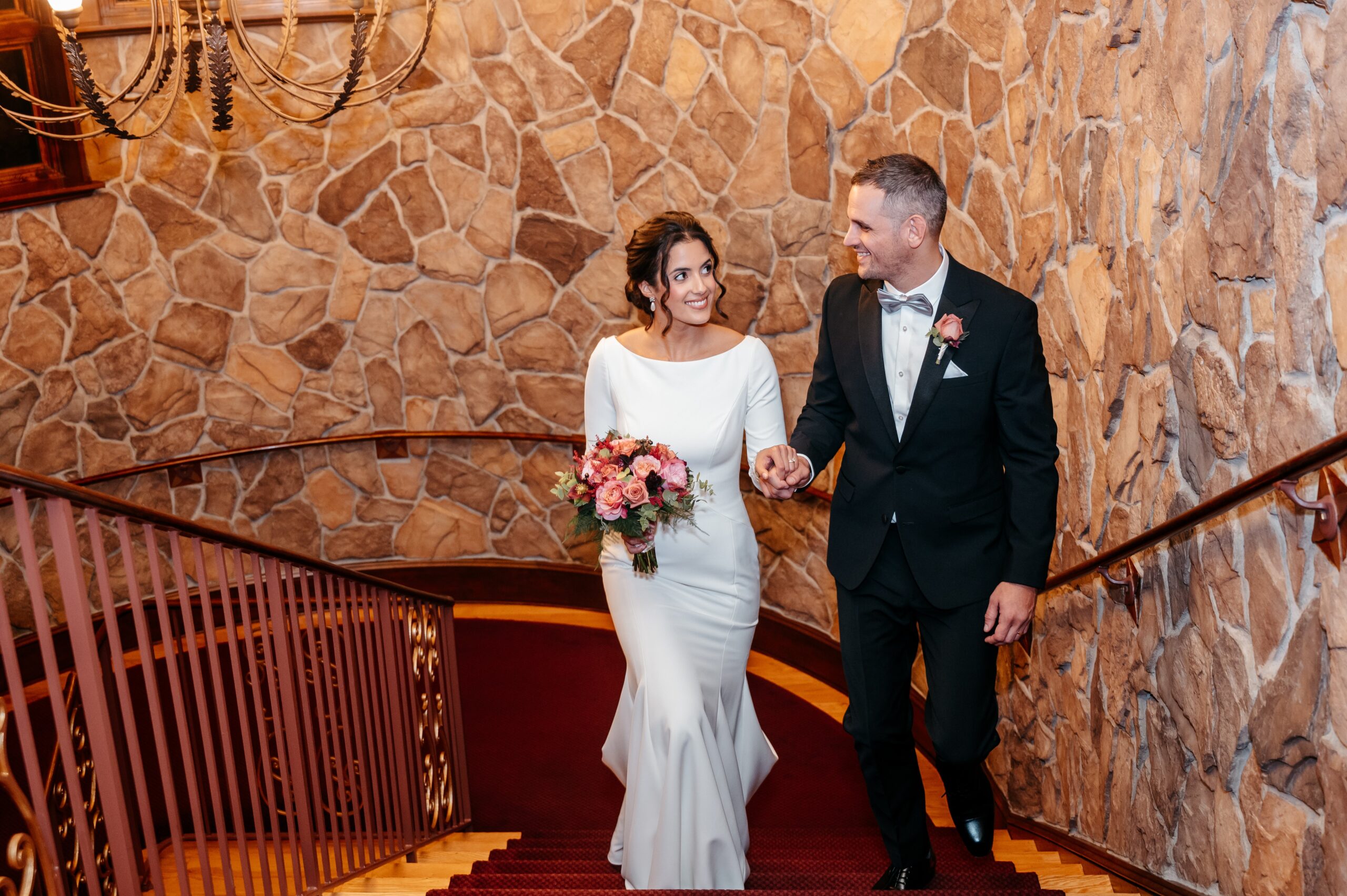 Bride and groom walking up a staircase at venue during wedding planning in Boston
