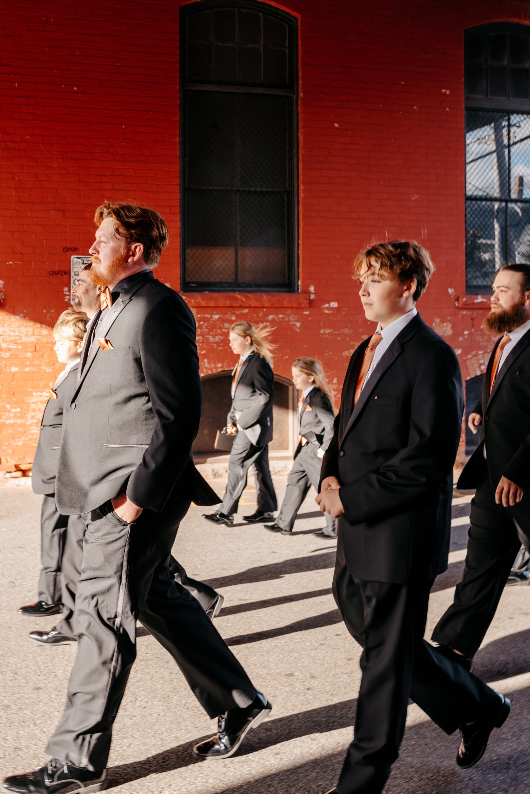 Groomsmen walking together in suits during Boston wedding planning day in urban setting