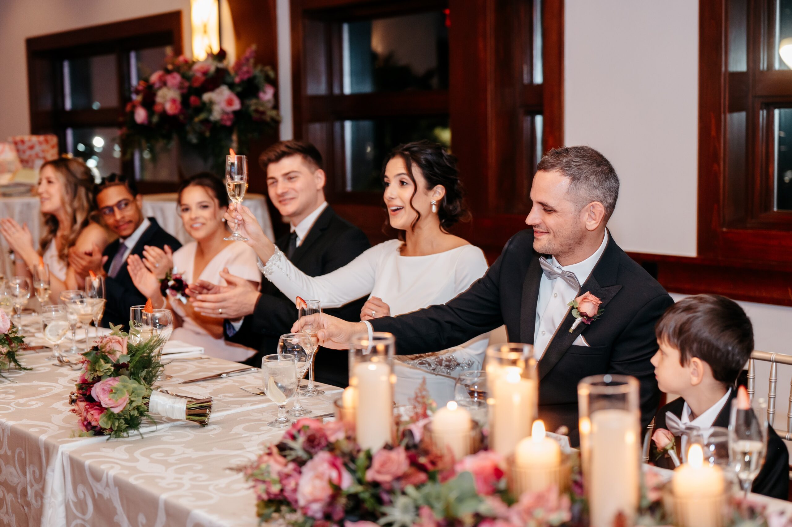 Bride and groom toasting with guests at Cafe Escadrille wedding reception in Burlington, elegant table setting and wedding cost value