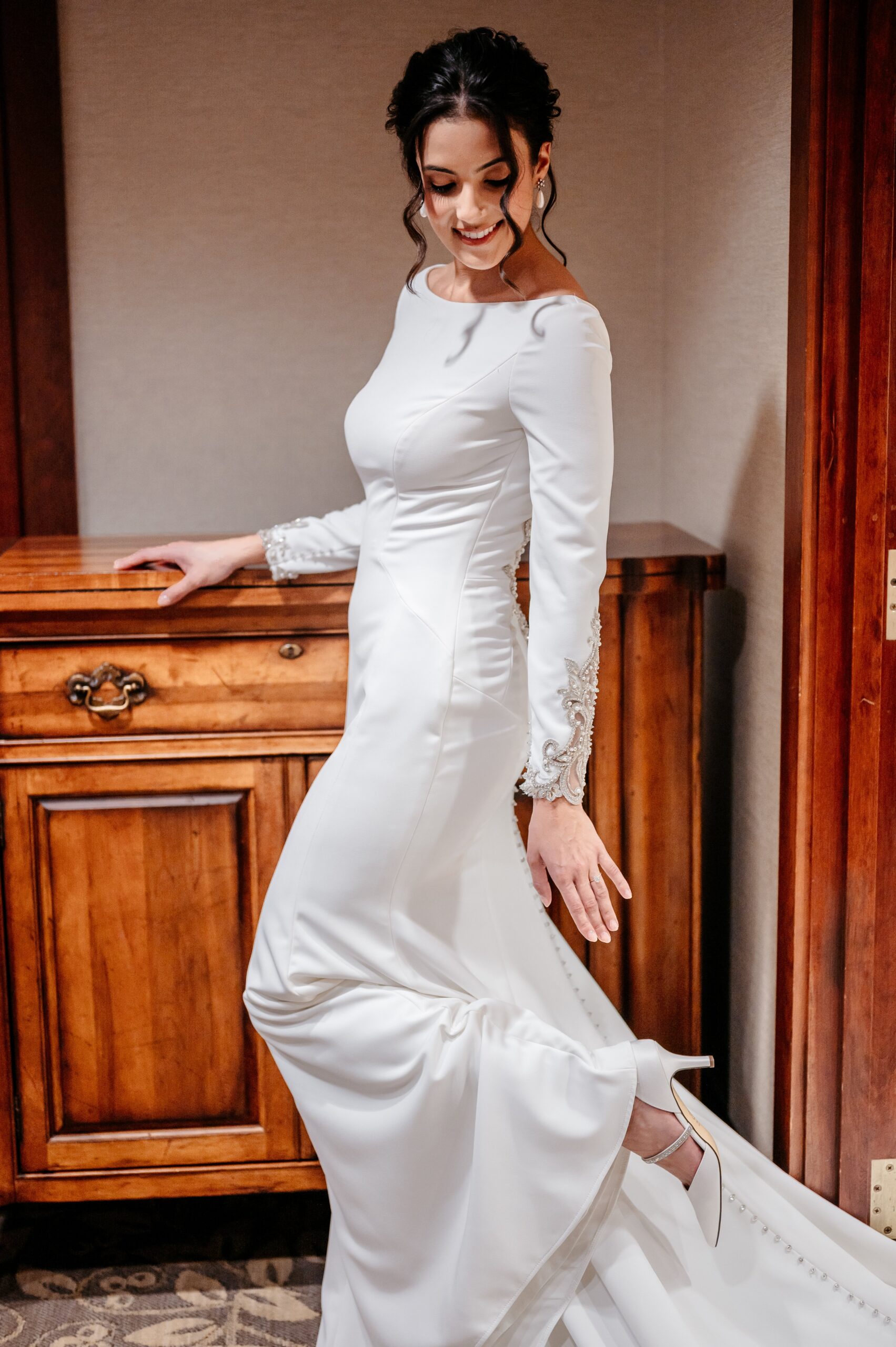 Bride posing in fitted gown at Burlington wedding at Cafe Escadrille, showcasing elegant silhouette and timeless bridal fashion