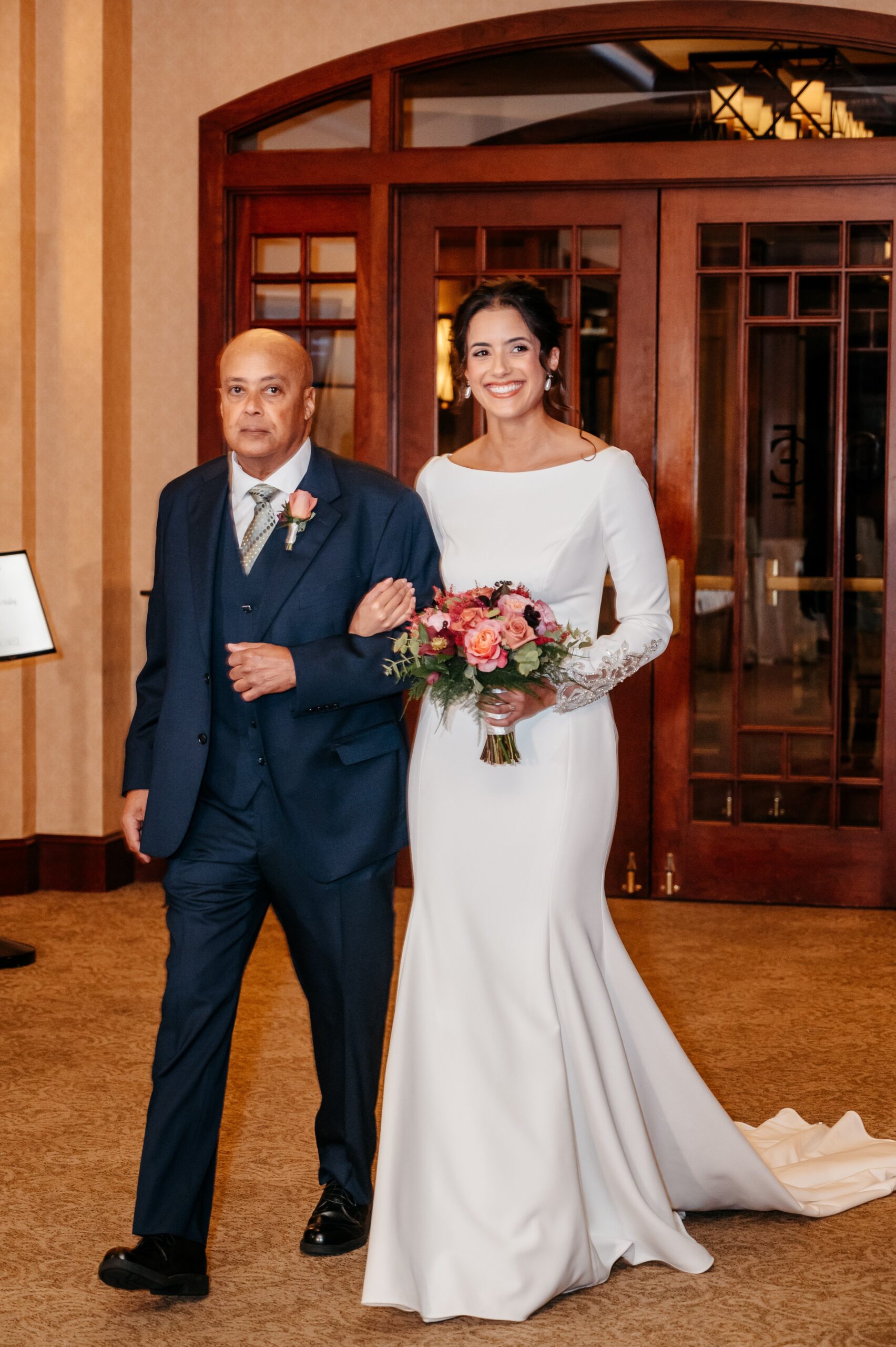 Bride walking down aisle with father at Cafe Escadrille wedding in Burlington, emotional ceremony entrance with bouquet