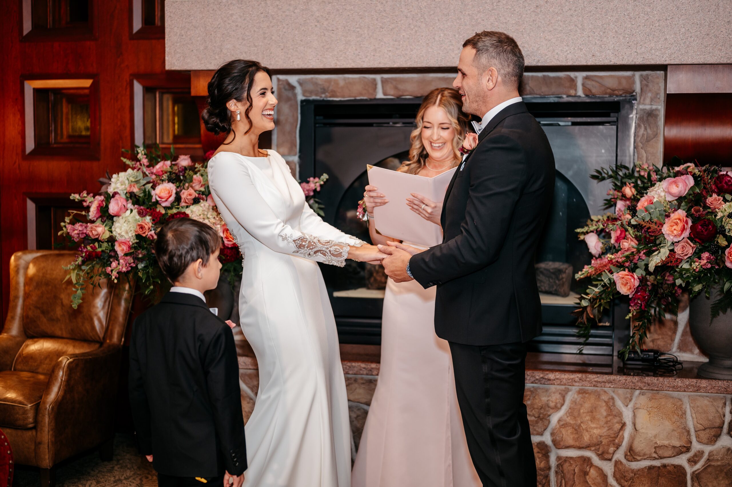 Couple exchanging vows during Burlington wedding at Cafe Escadrille, intimate indoor ceremony with floral arrangements