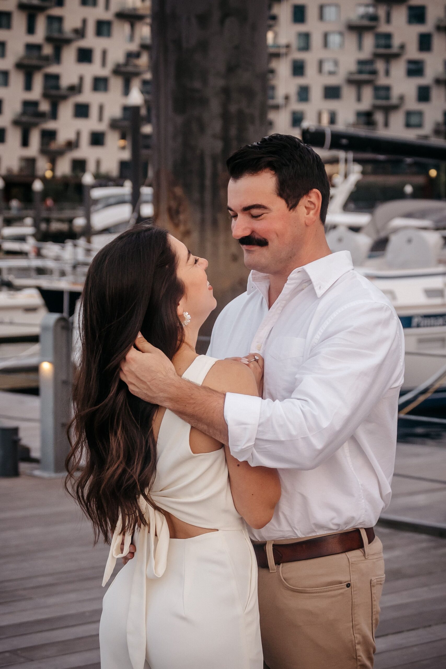 Romantic embrace during Fan Pier Park engagement session, couple holding each other near the Boston waterfront