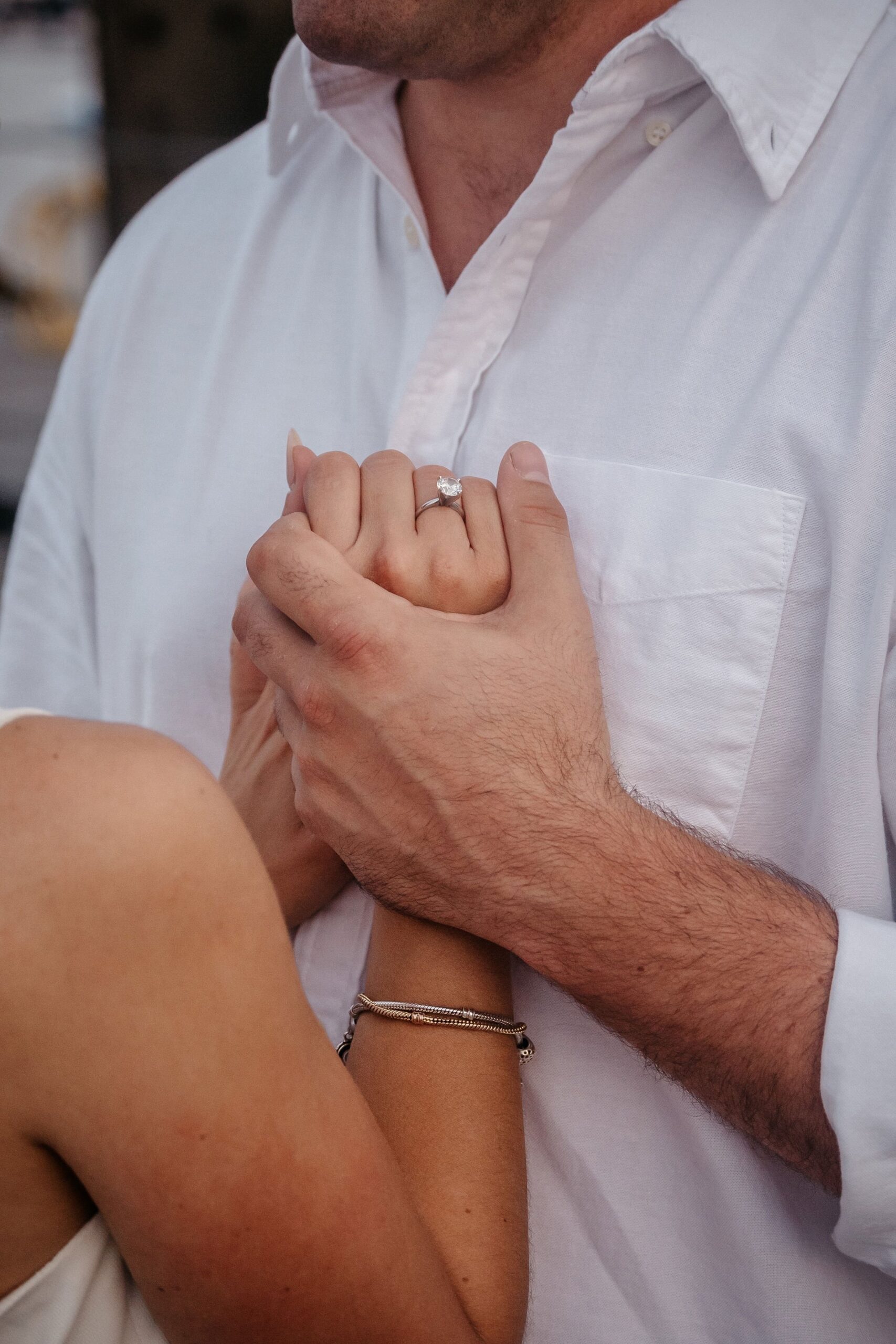 Engagement ring detail during Fan Pier Park Boston engagement session, close-up of couple holding hands at sunset