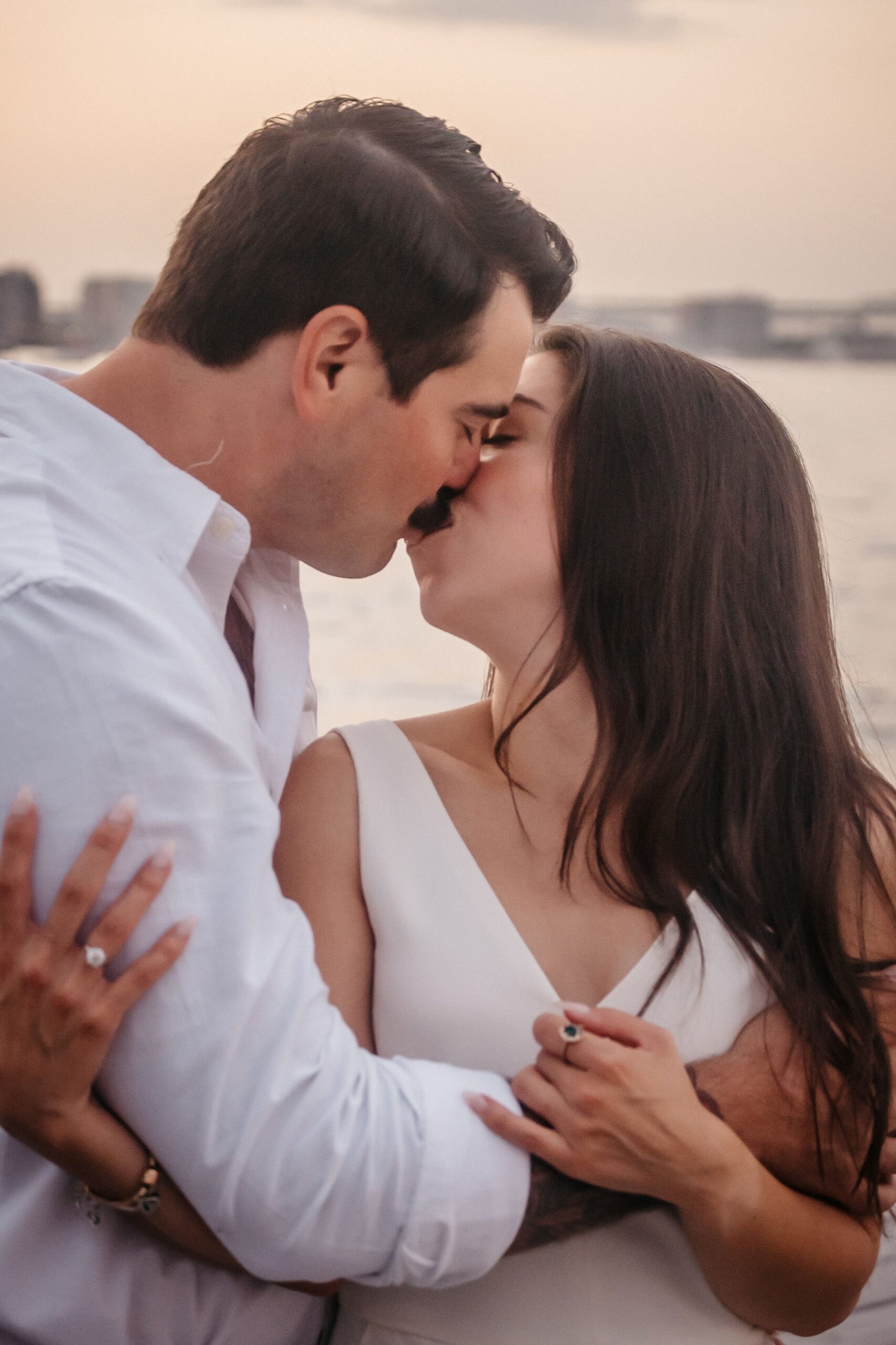 Close-up of couple kissing during Fan Pier Park engagement session at sunset, intimate Boston waterfront moment