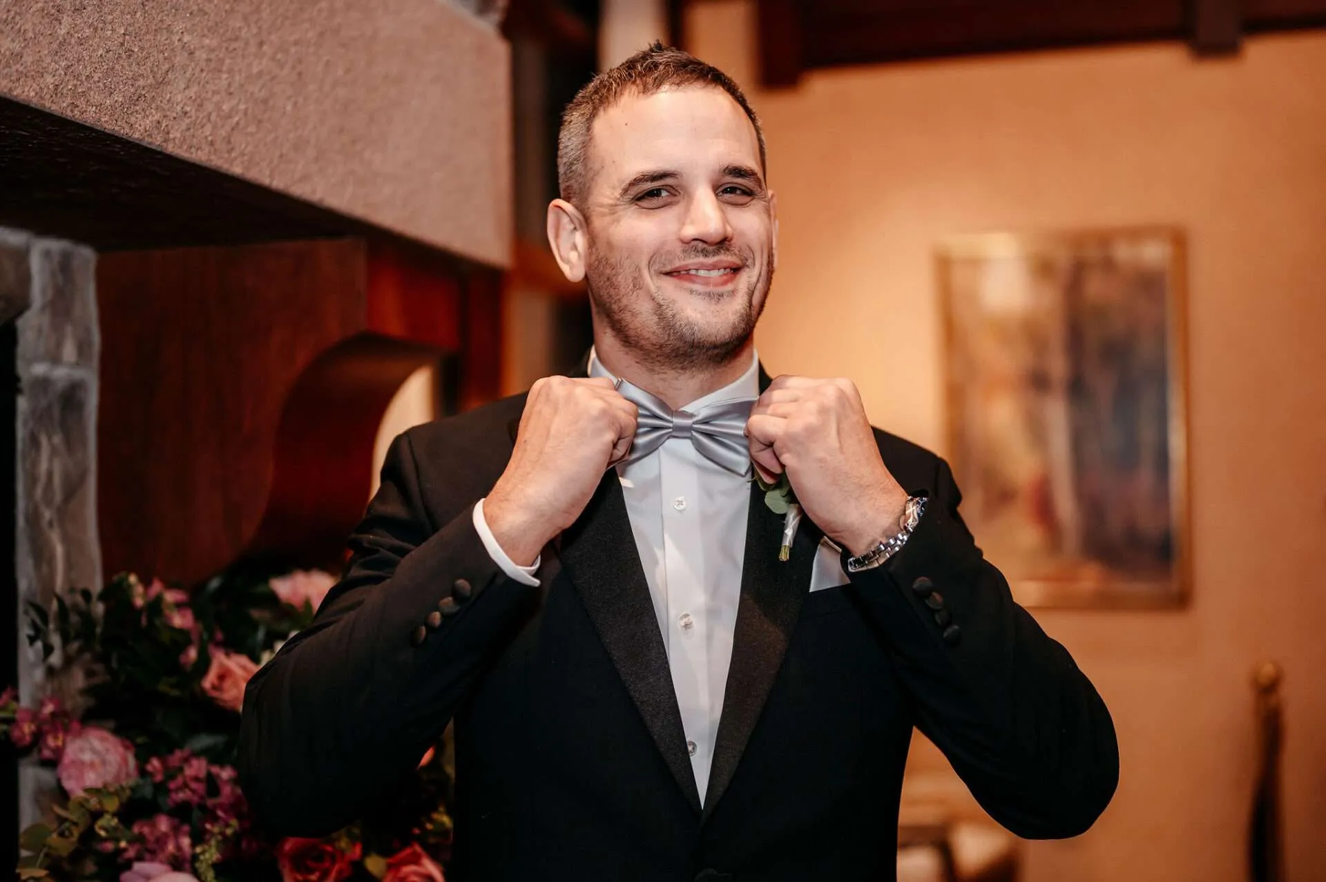 Groom adjusts his bow tie and smiles at his wedding in Burlington wedding locations