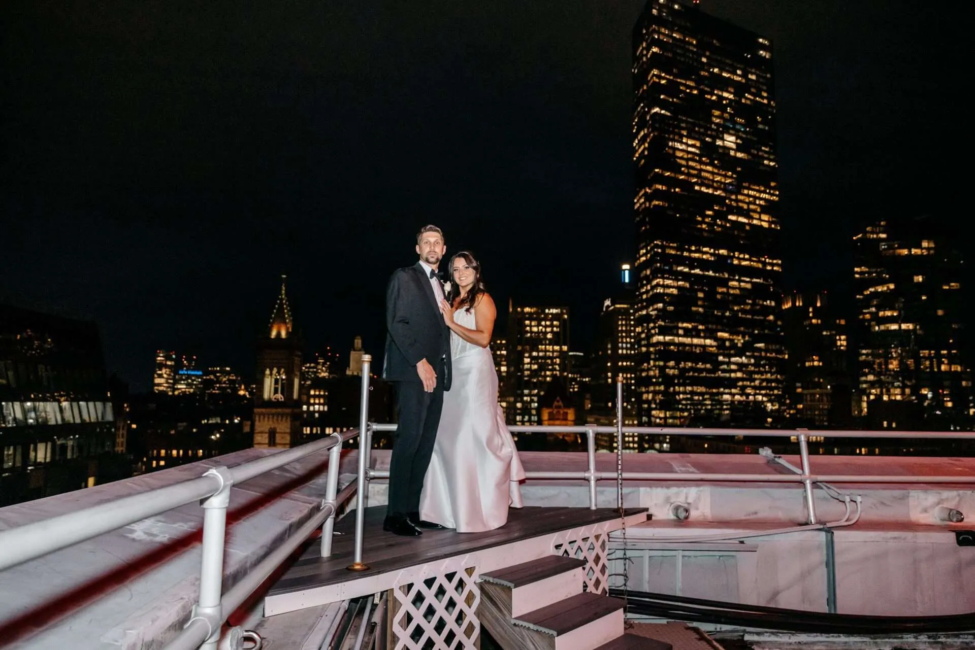 Husband and wife stand on rooftop after getting married in massachusetts
