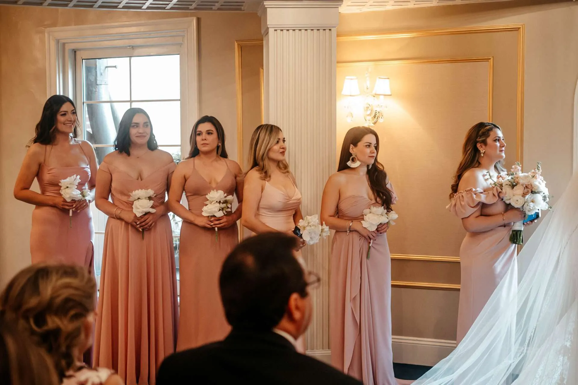Bridesmaids look at bride while she is getting marriedin Massachusetts