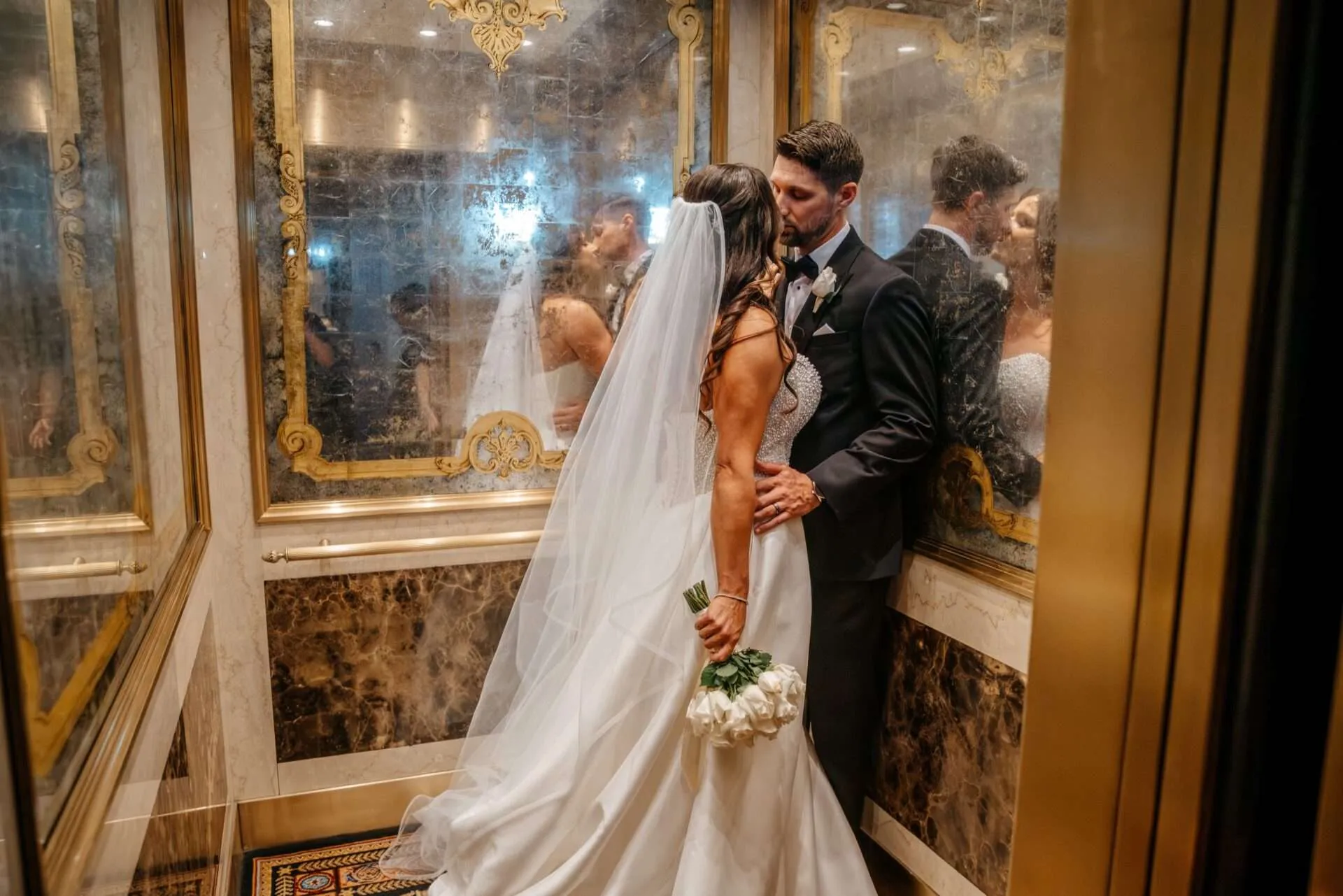 Husband and wife share a kiss in an elevator while getting married in massachusetts
