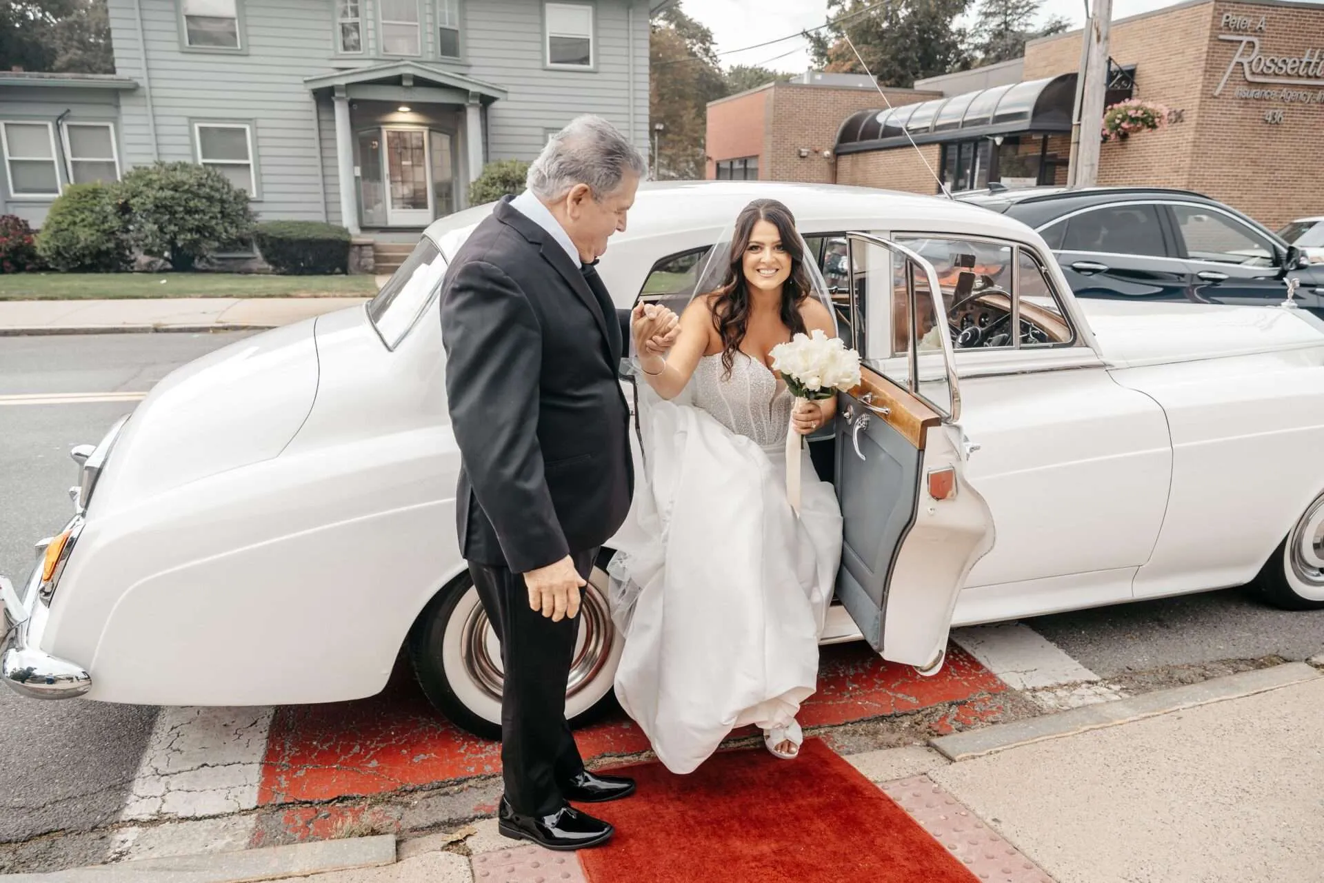 Bride steps out of white car while getting married in massachusetts