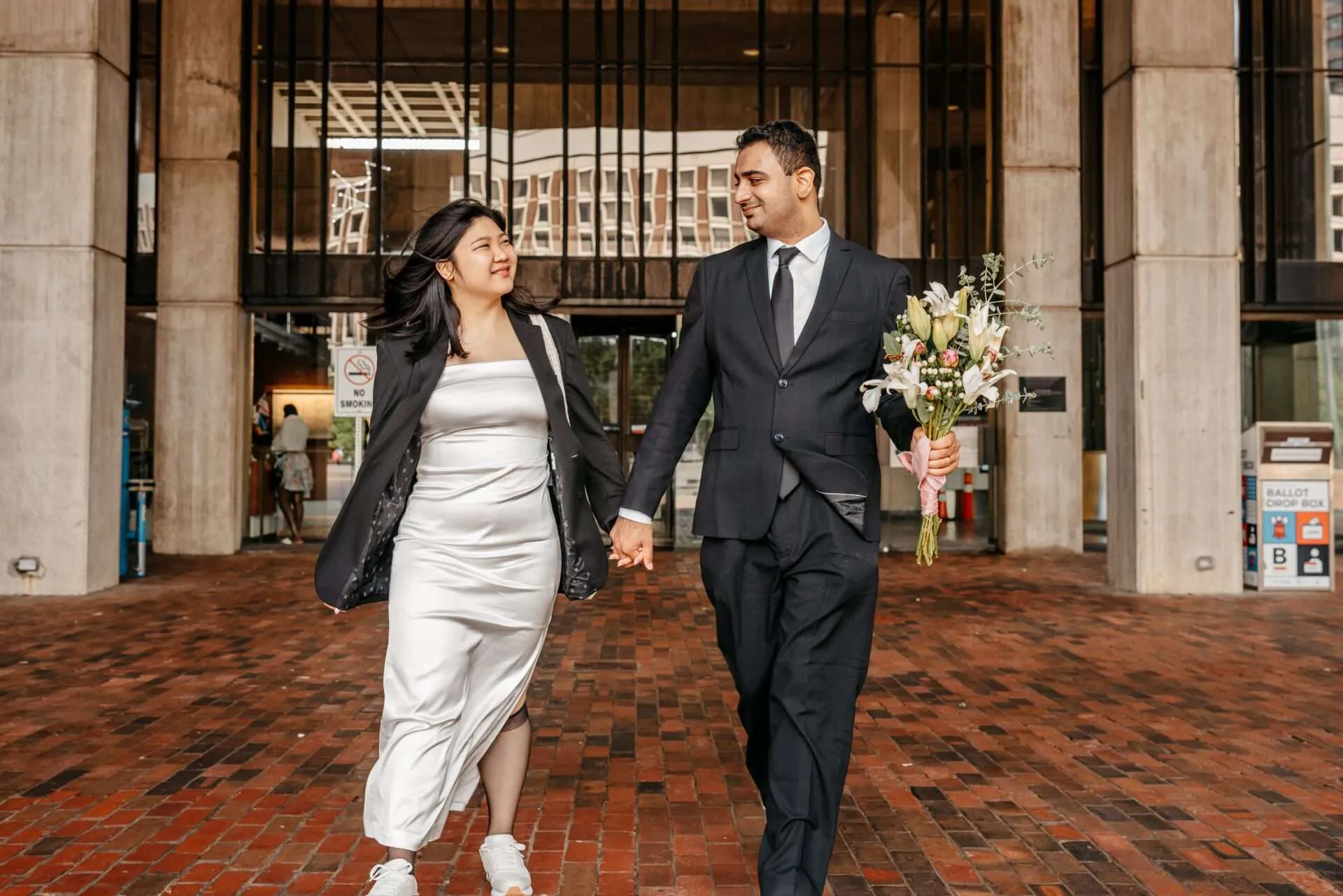 Bride and groom exit city hall after getting married in massachusetts