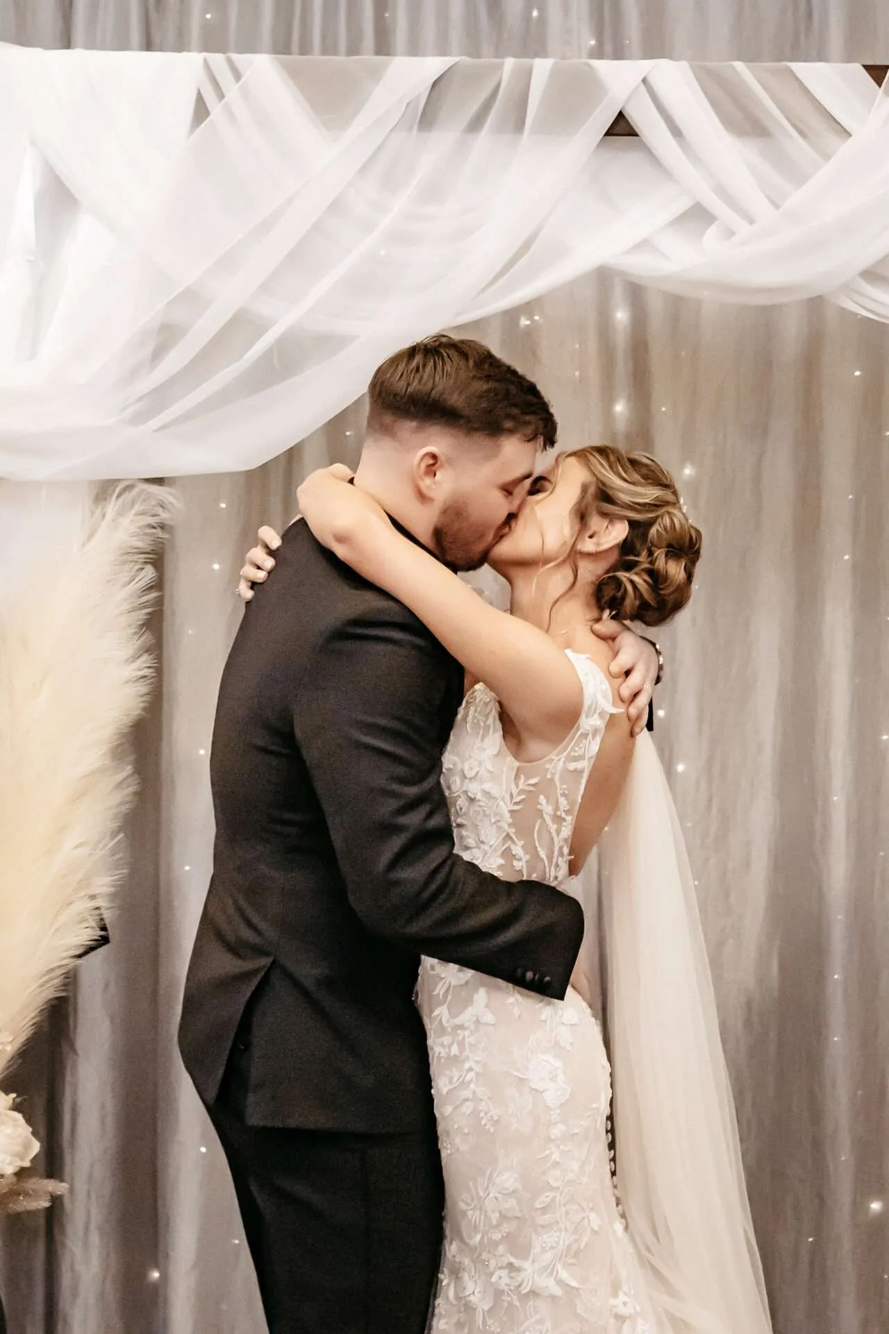 Bride and groom kiss at the alter knowing the average wedding photographer cost Boston