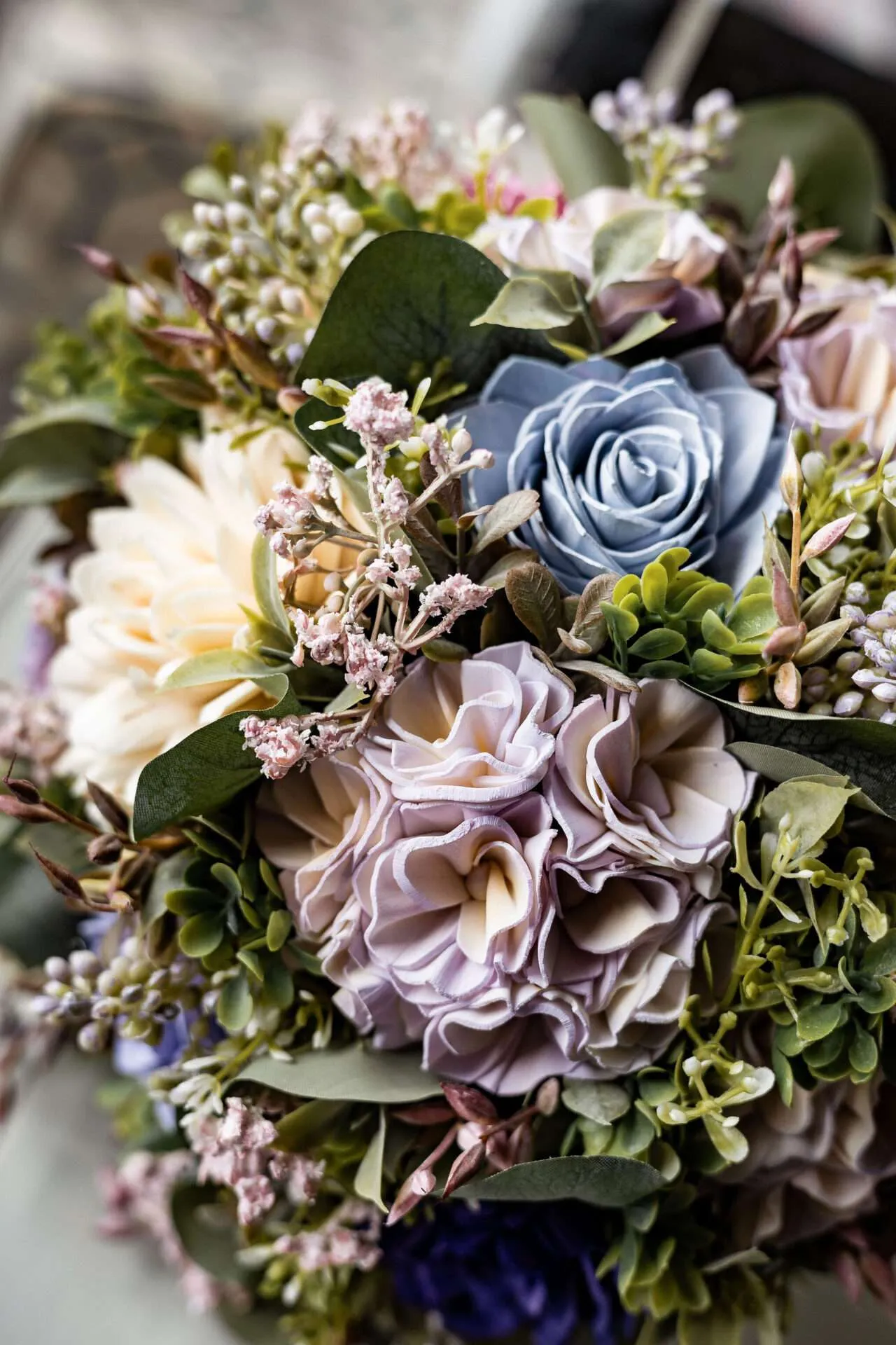 A bouquet of blue, lilac, and white fowers are displayed in a Seaport wedding venue