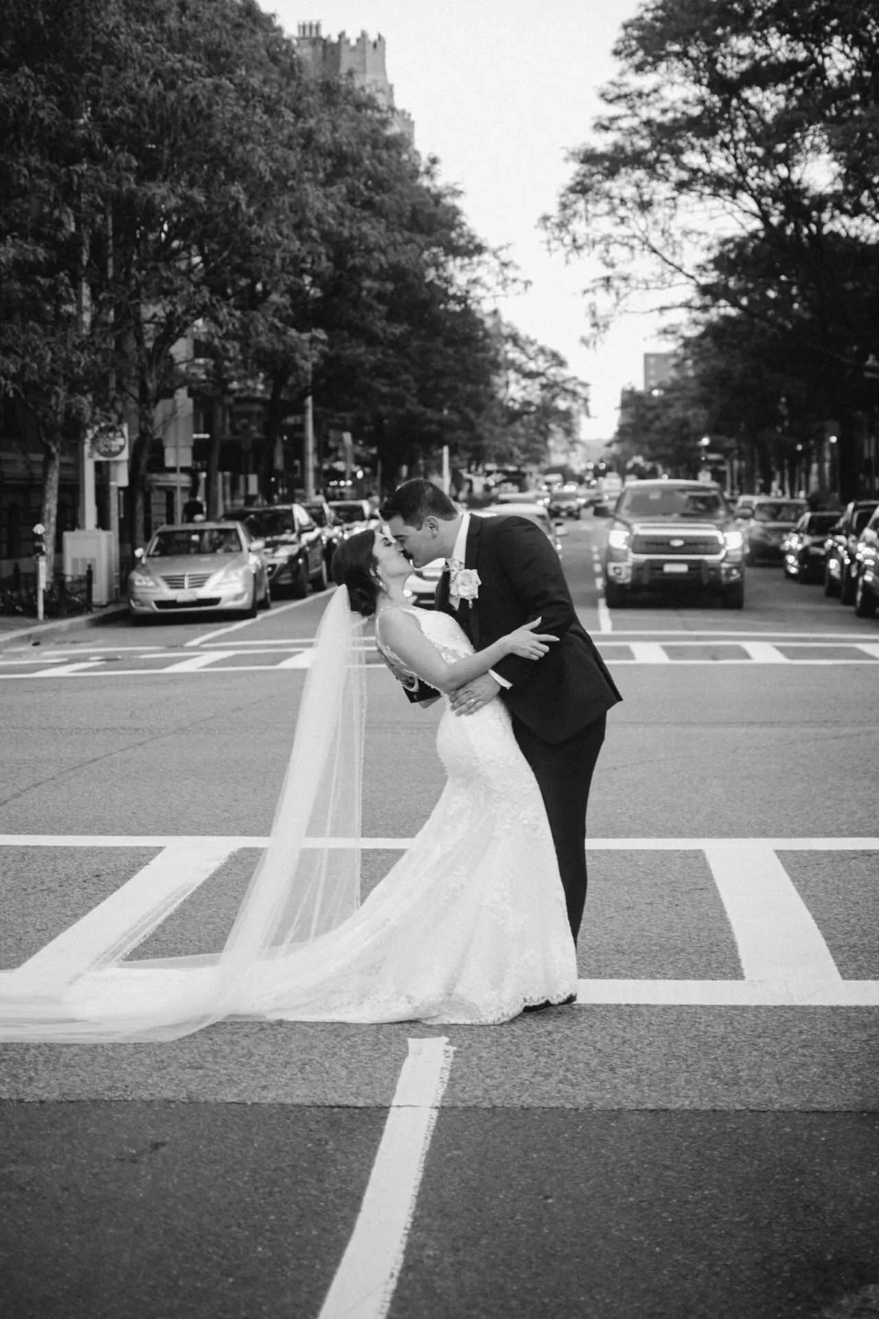 bride and groom kissing in street